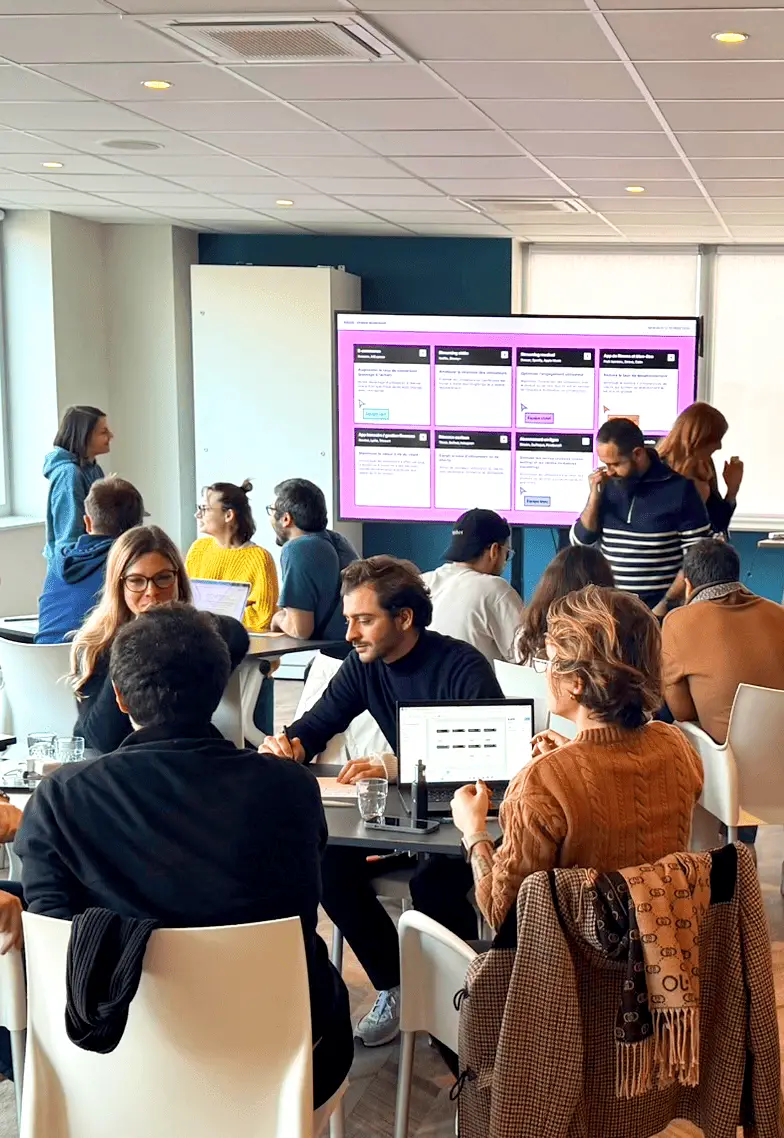 Équipe de l'agence design UX UI en session de brainstorming créatif, travaillant sur de nouveaux projets numériques.