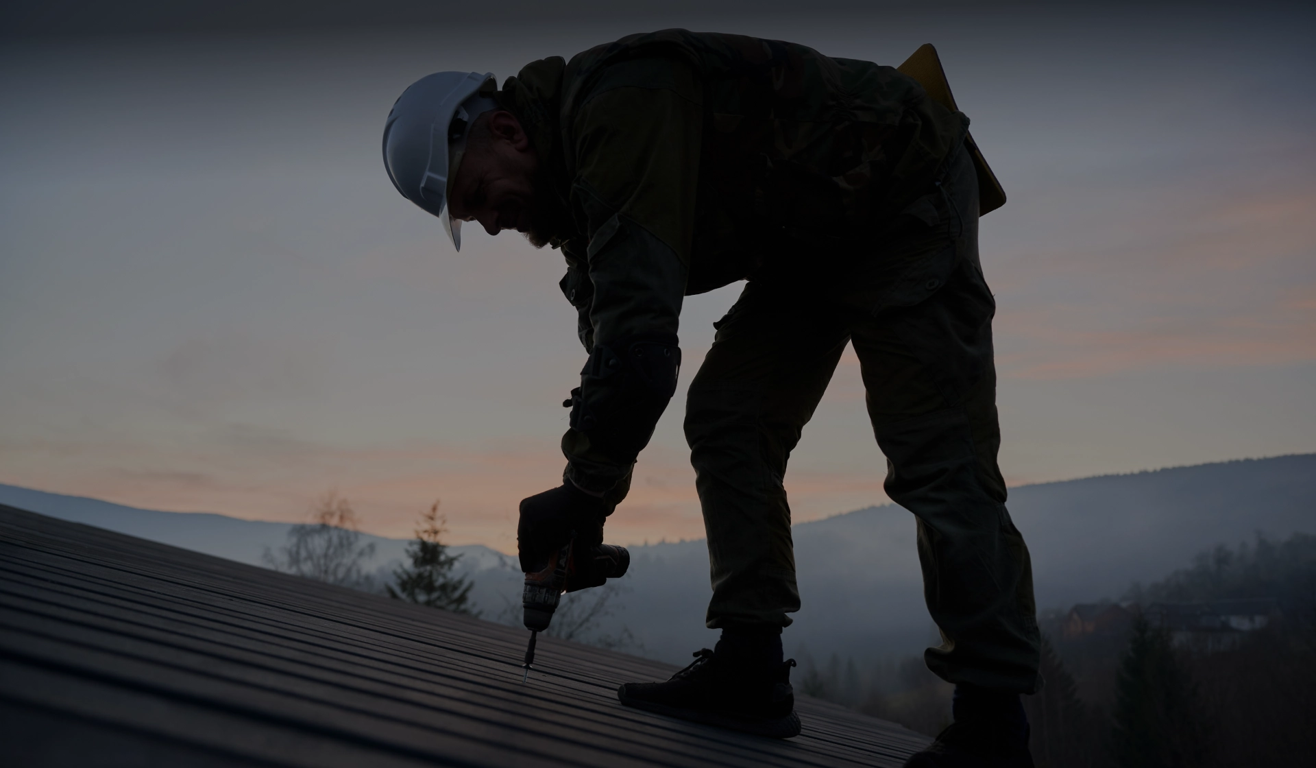 worker on rooftop wearing hard hat