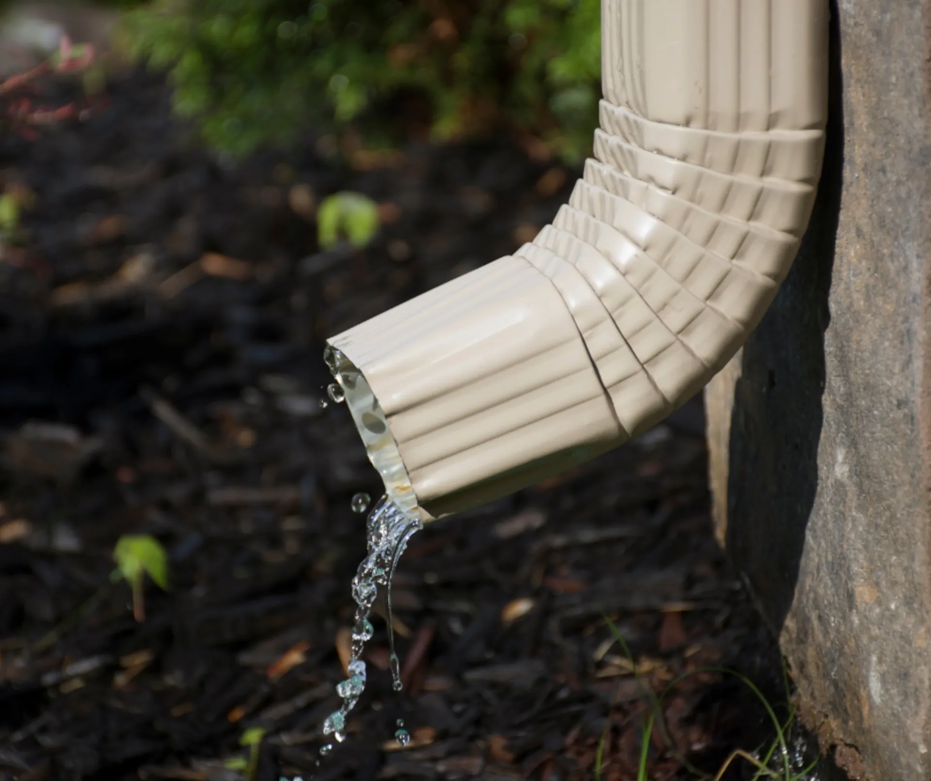 white aluminum downspout pouring out water