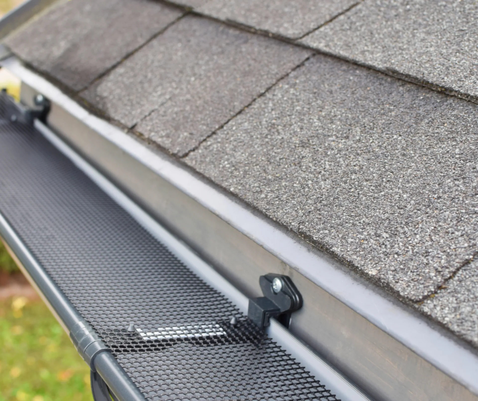 new gutter guards installed on the gutters of a shingle roof