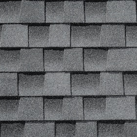 Close-up of gray asphalt shingles arranged in staggered rows on a roof.