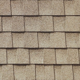 Close-up view of textured golden amber asphalt roof shingles arranged in overlapping rows.