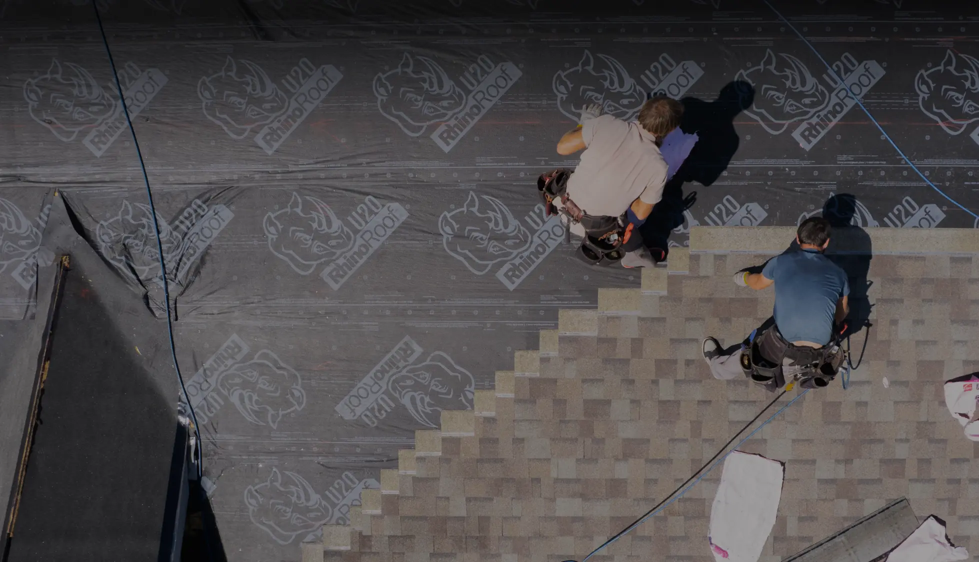 workers adding roof shingles during roof replacement
