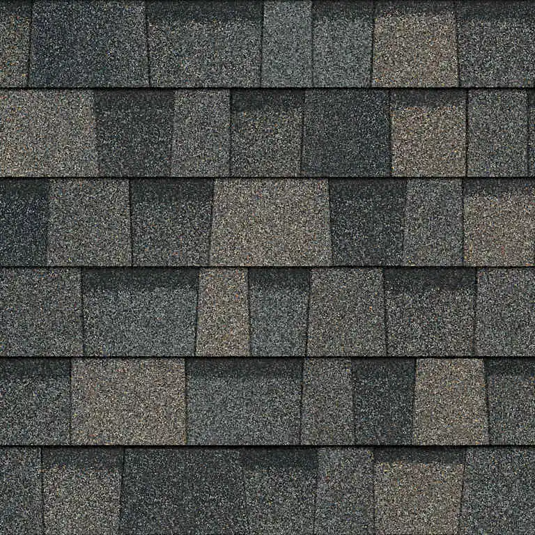 Close-up of asphalt roof shingles in mixed dark gray and brown tones arranged in rows.