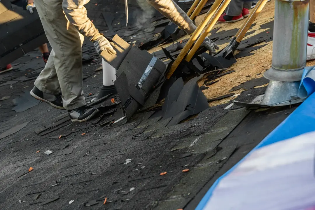 tearing up roof shingles with tools