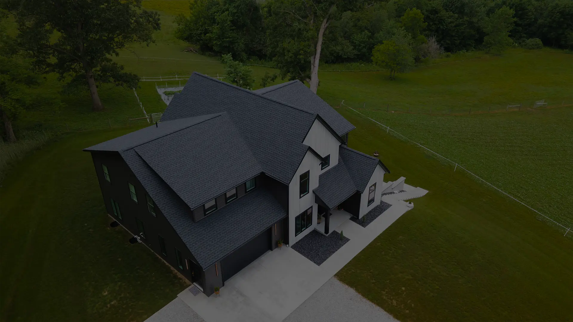 Overhead drone view of a completed gray architectural shingle roof on a ranch home