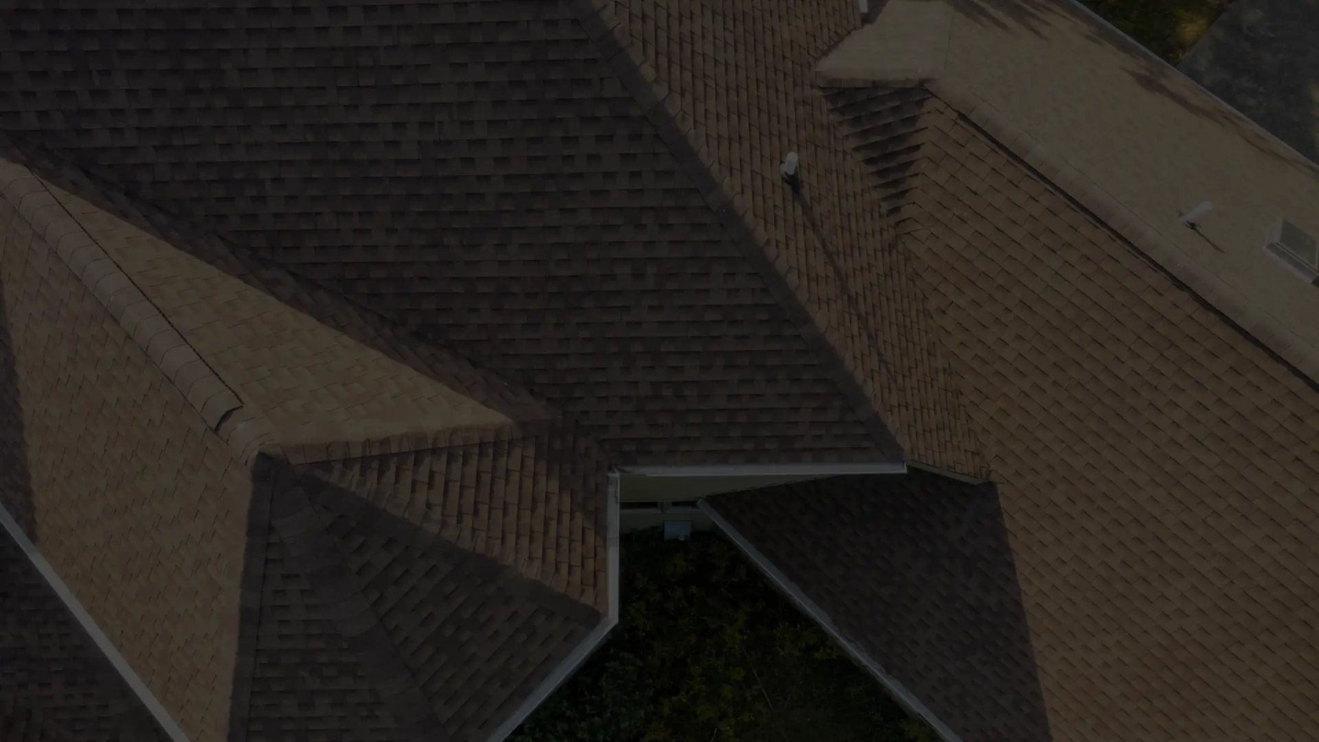 Overhead drone view of a completed gray architectural shingle roof on a ranch home