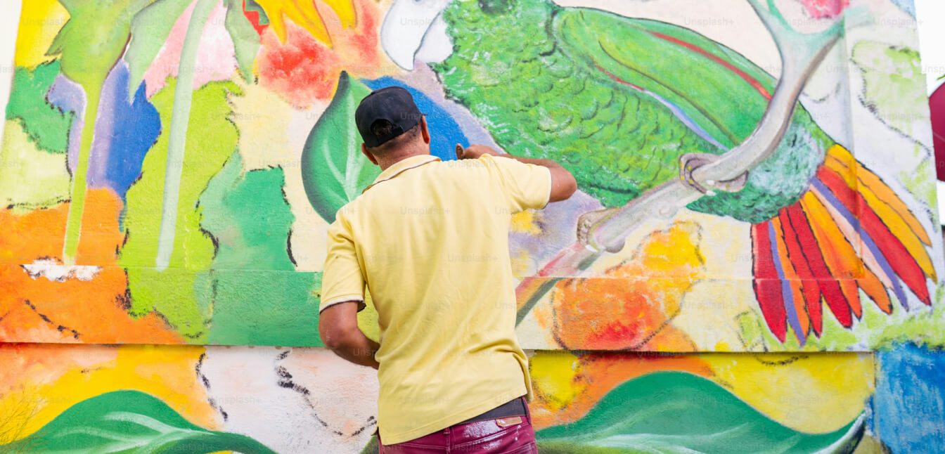 Man painting a bright community mural