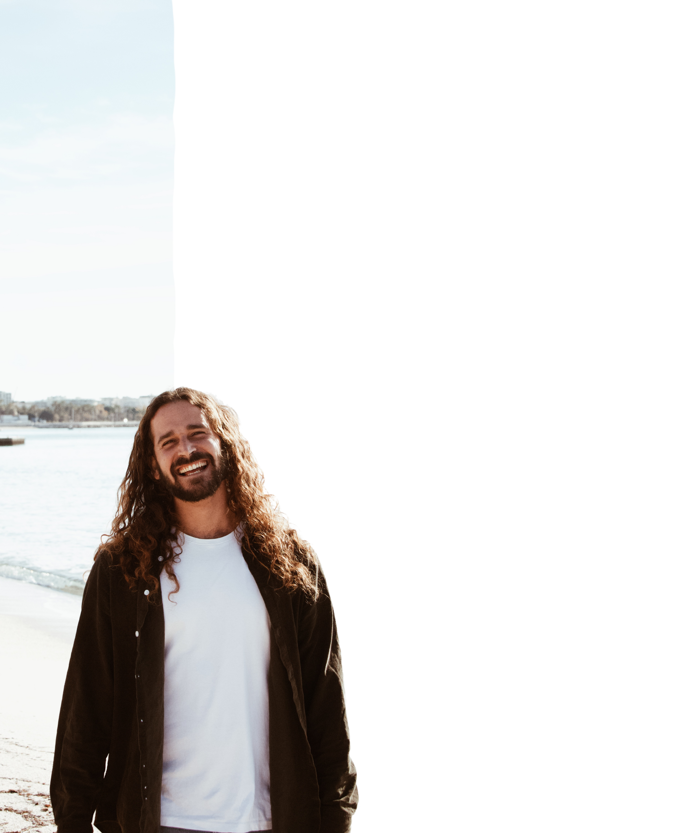Portrait of Ivan Blanco, UI/UX Designer, standing on a beach smiling,