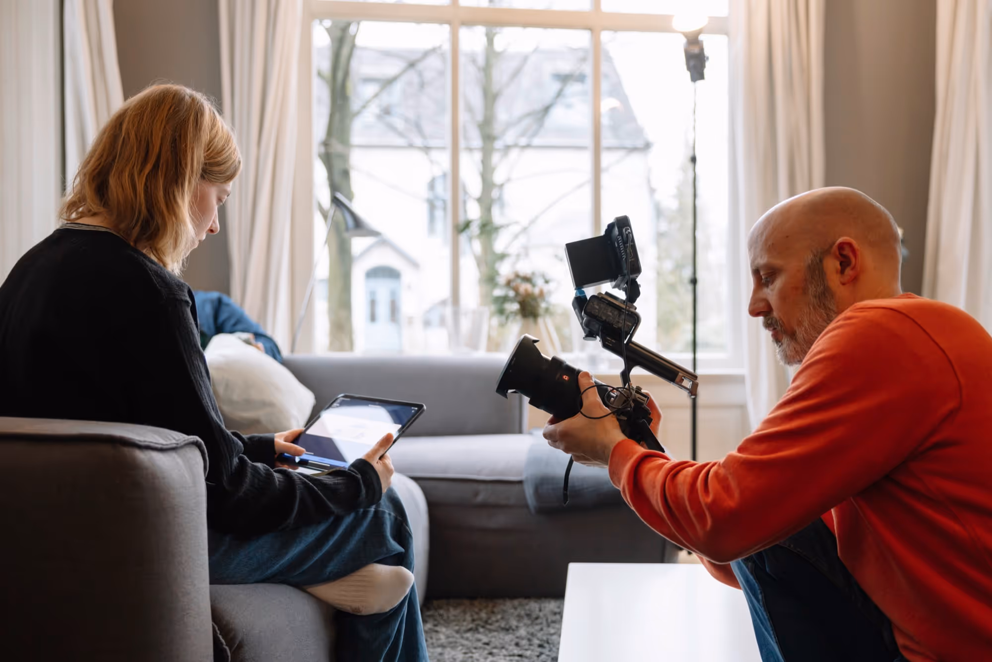 Ein Fotograf nimmt eine Frau mit Tablet auf.