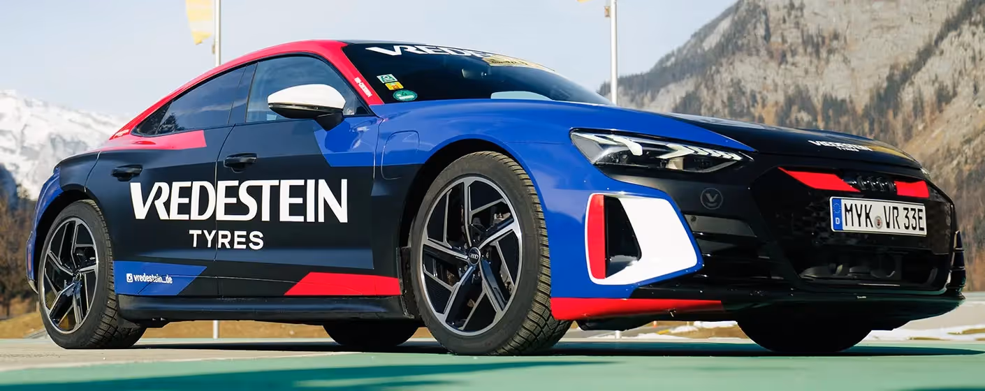 Ein Audi der in den Bergen steht und mit Vredestein Tyres beklebt ist.
