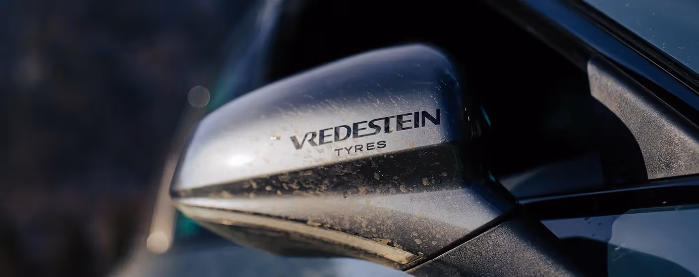 Der Rückspiegel eines Autos ist mit Vredestein Tyres beklebt.