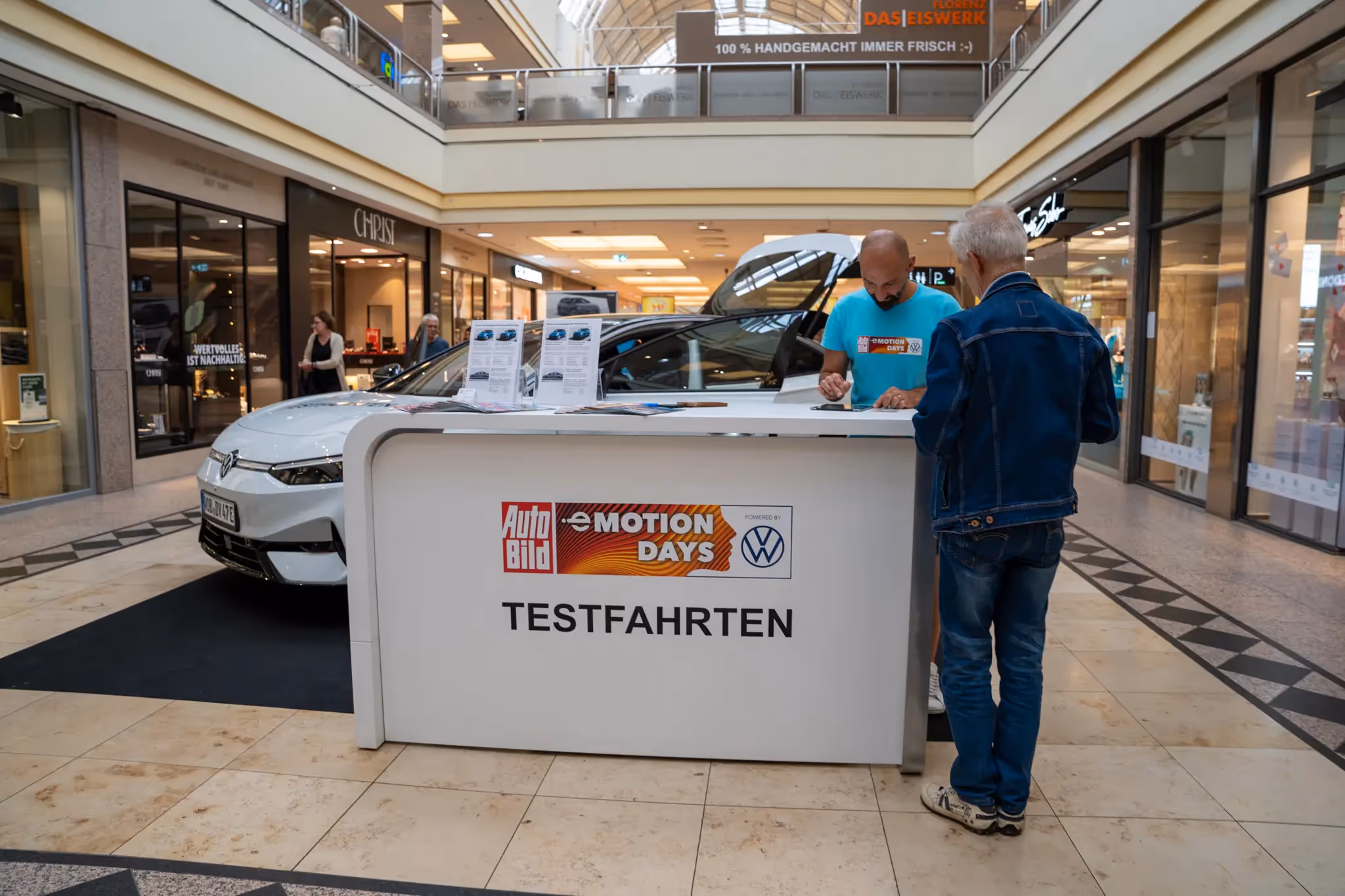 Ein Aufsteller und ein weißer VW stehen in einem Einkaufszentrum und sind mit den Auto Bild Emotion Days gebrandet.