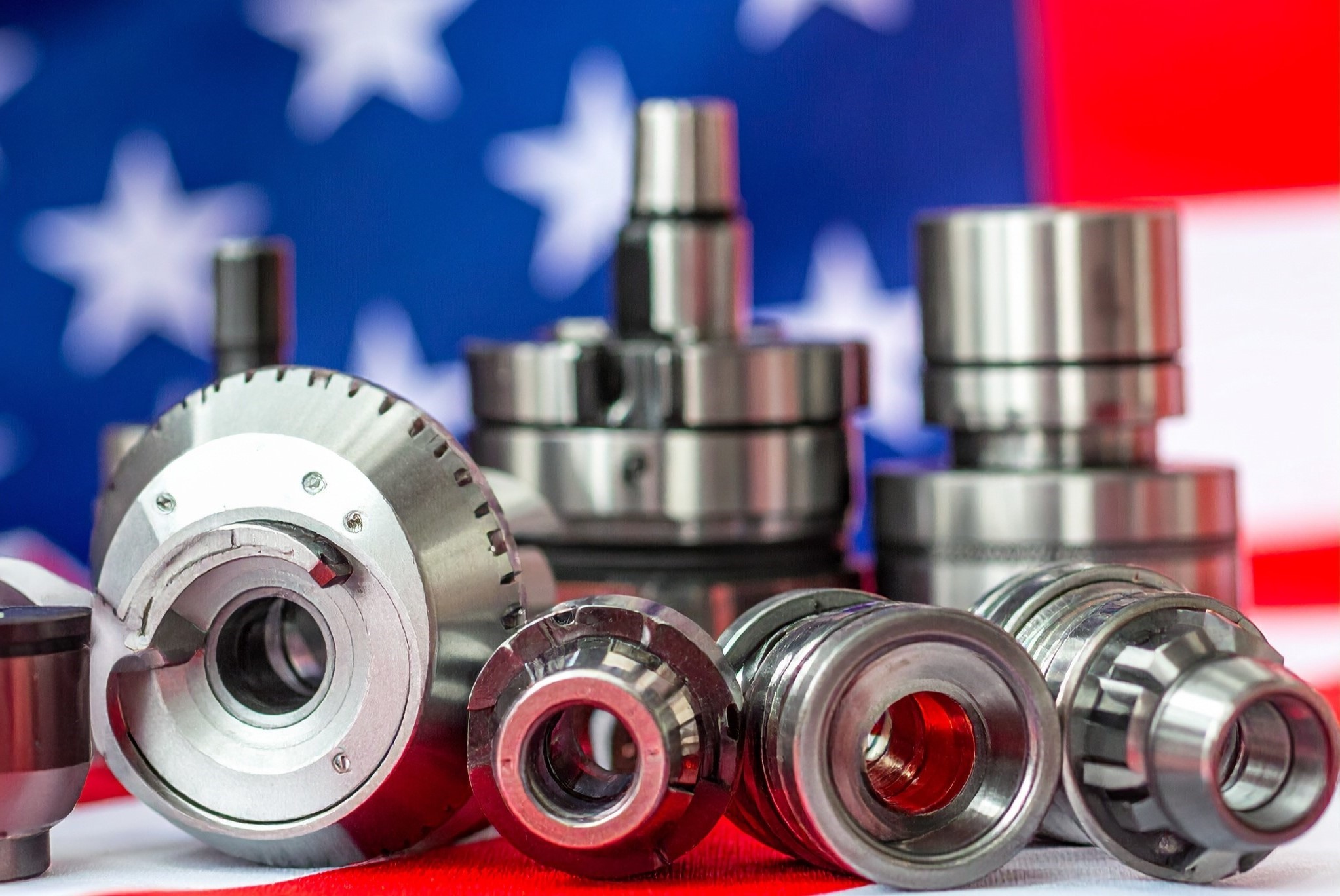 Various metal industrial parts placed on an American flag background.
