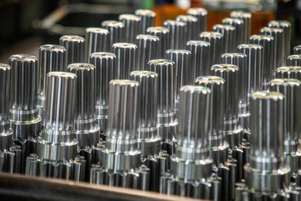 Rows of shiny, metallic gear shafts arranged closely together.