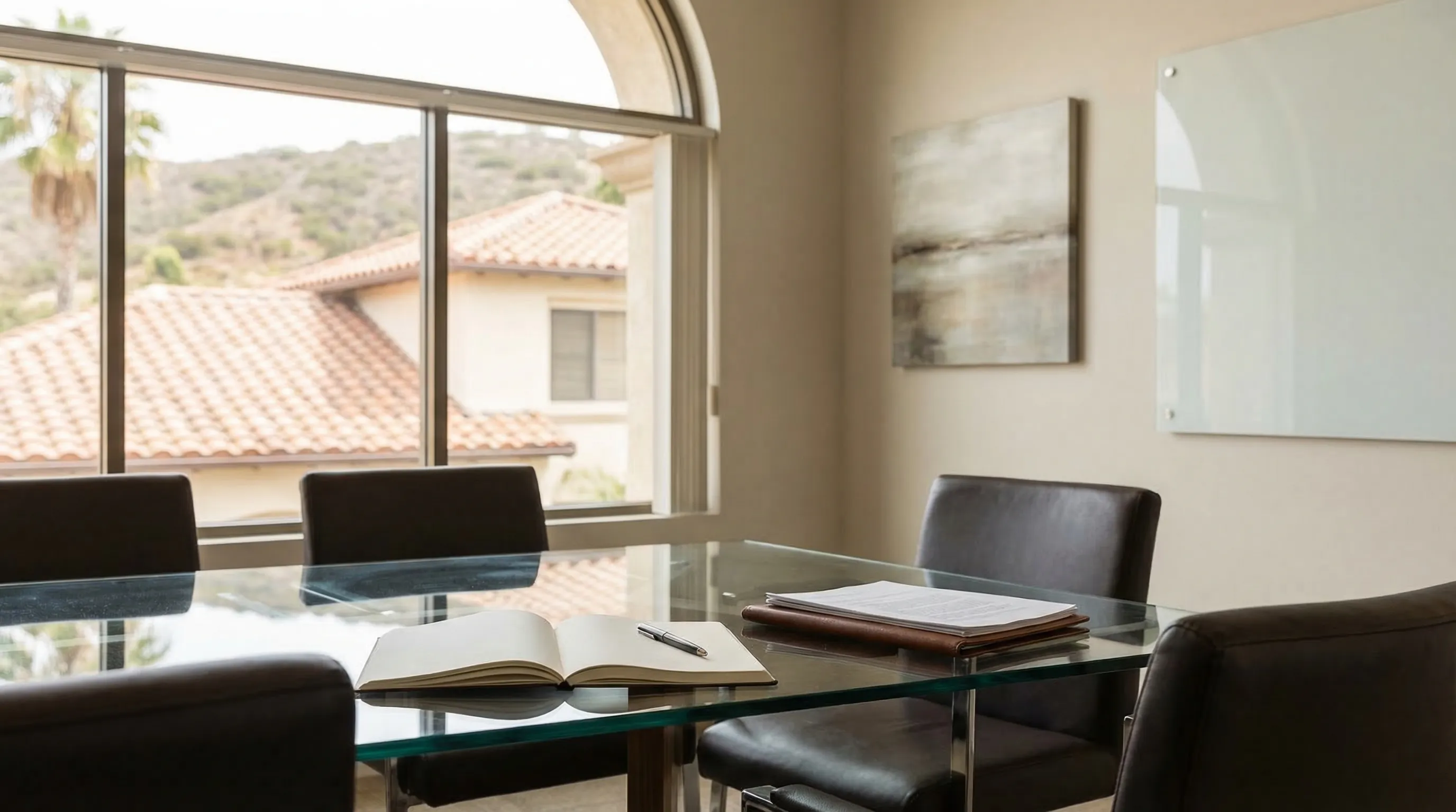 Professional law office interior in San Diego, CA with attorney meeting client across a glass conference table