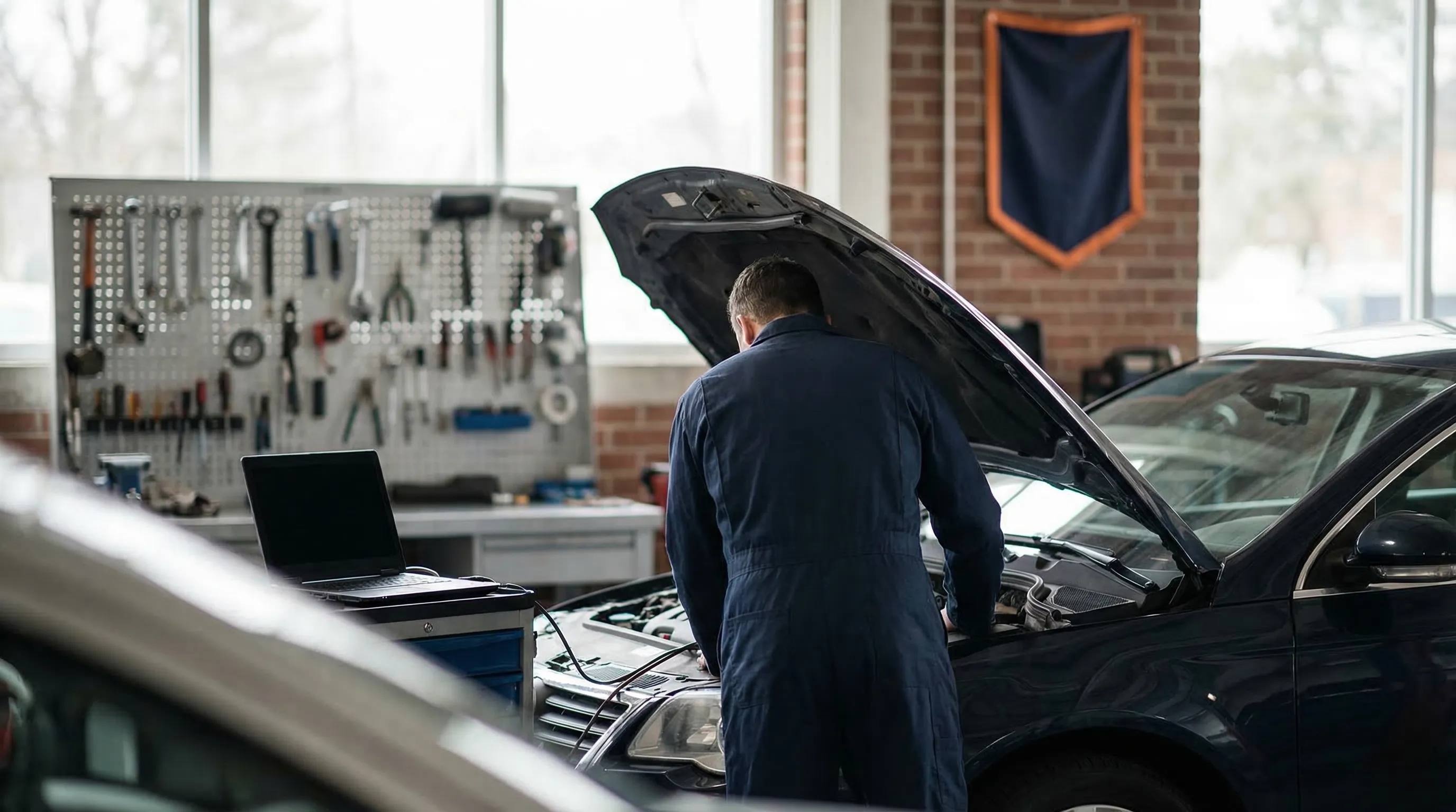 Professional auto repair shop interior with mechanic working on a vehicle in Detroit, MI