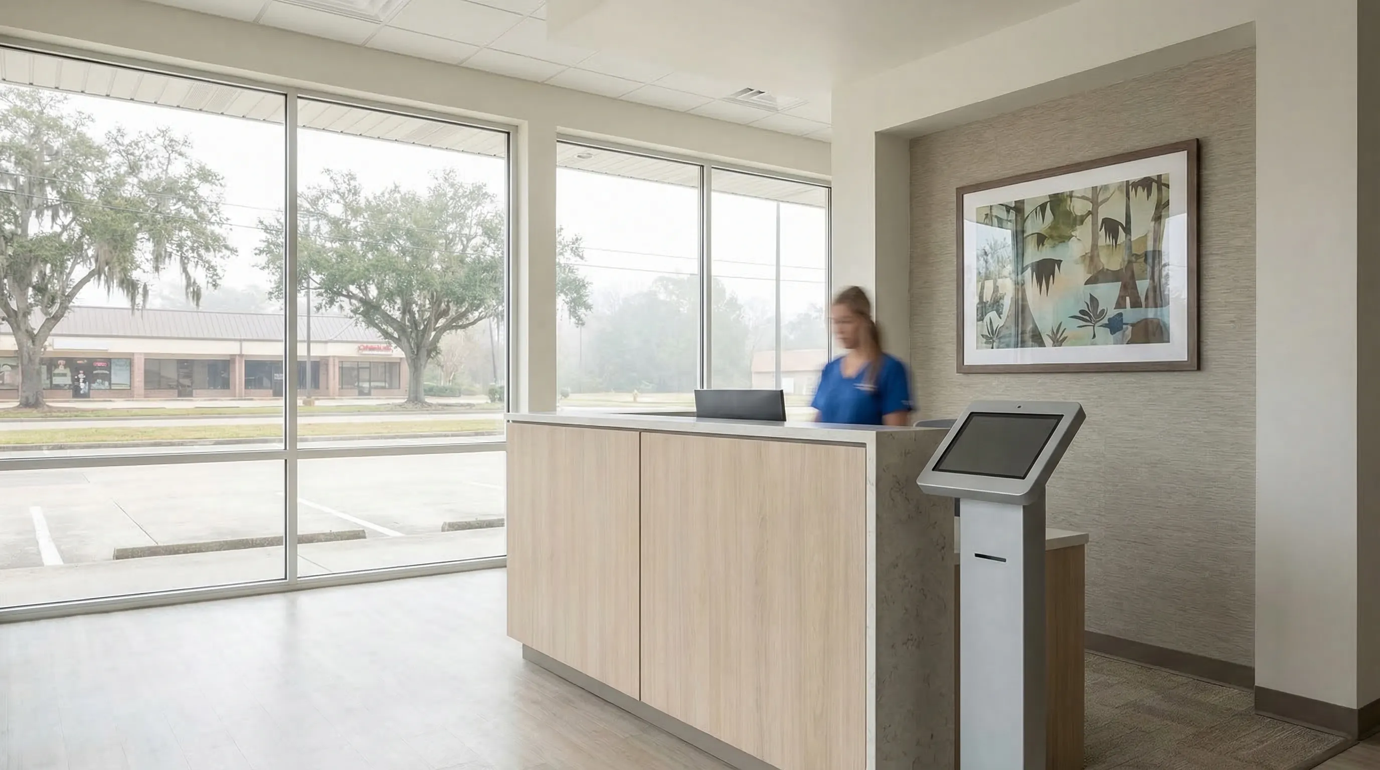 Professional physician in a white coat consulting with a patient in a clean, modern Baton Rouge clinic exam room, with a window showing a flat Louisiana suburban streetscape outside.