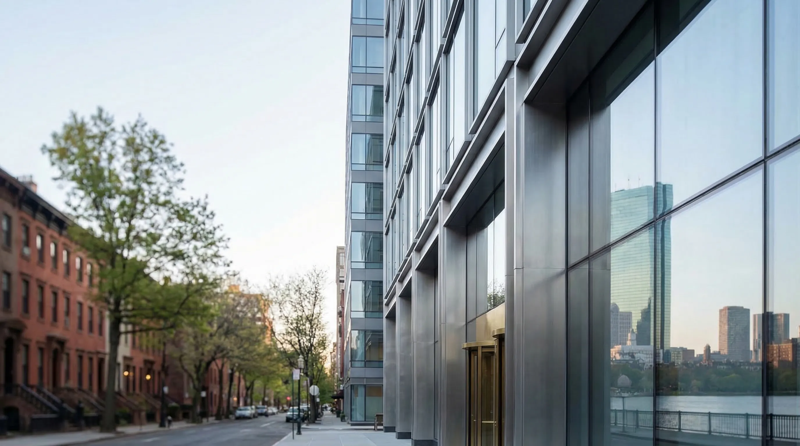 Professional financial advisory office interior in Boston's Financial District, two professionals reviewing portfolio charts at a modern desk with harbor view