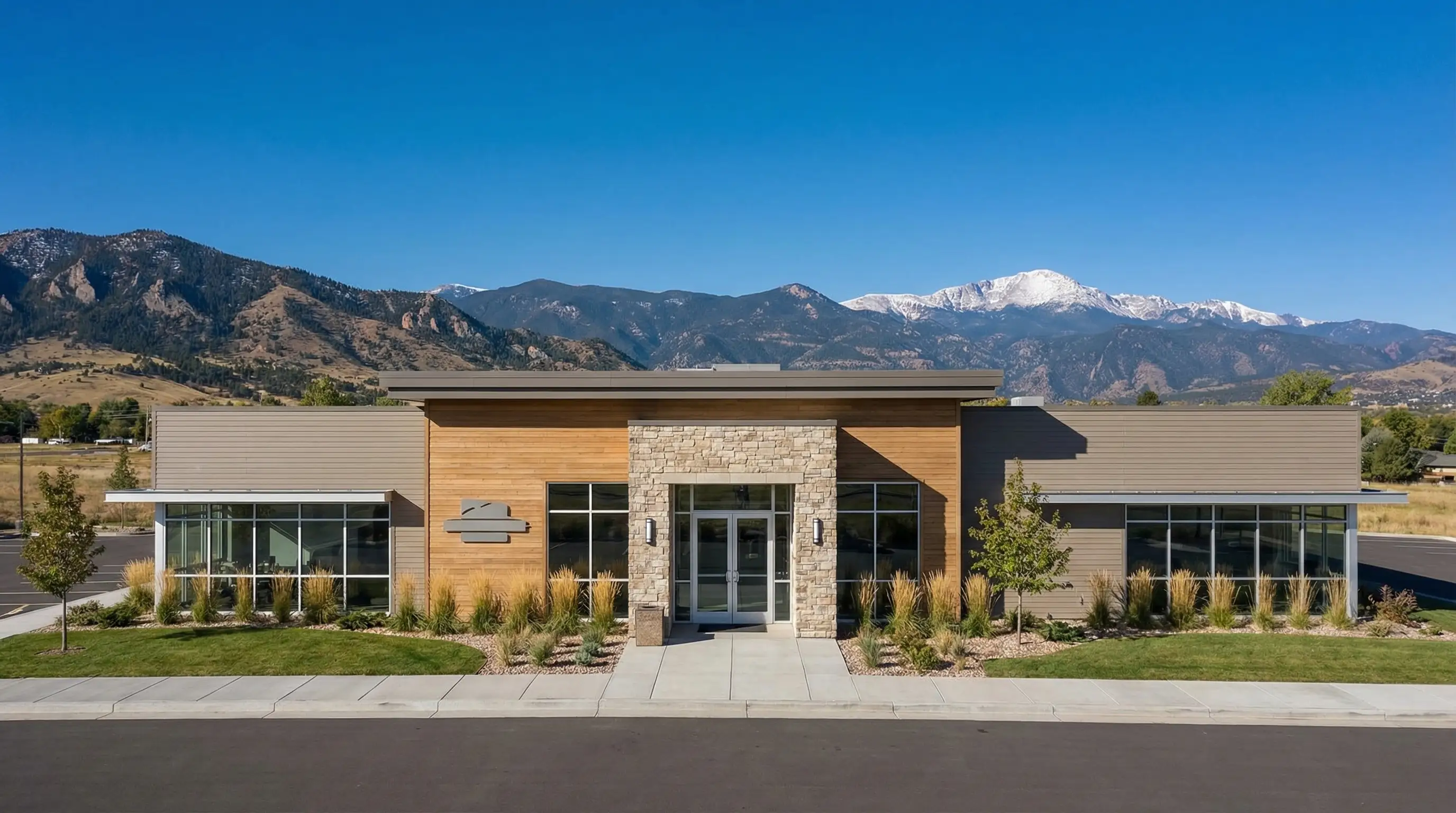 Professional financial advisor reviewing investment portfolio with a client couple in a modern Lakewood, CO office with natural light and mountain view