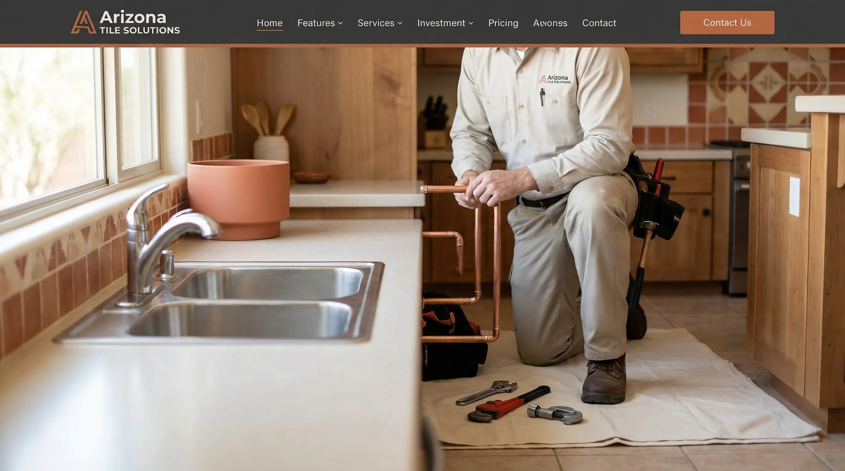 Professional plumber in a clean branded uniform inspecting under a kitchen sink in a modern Glendale home with Arizona tile backsplash and natural light