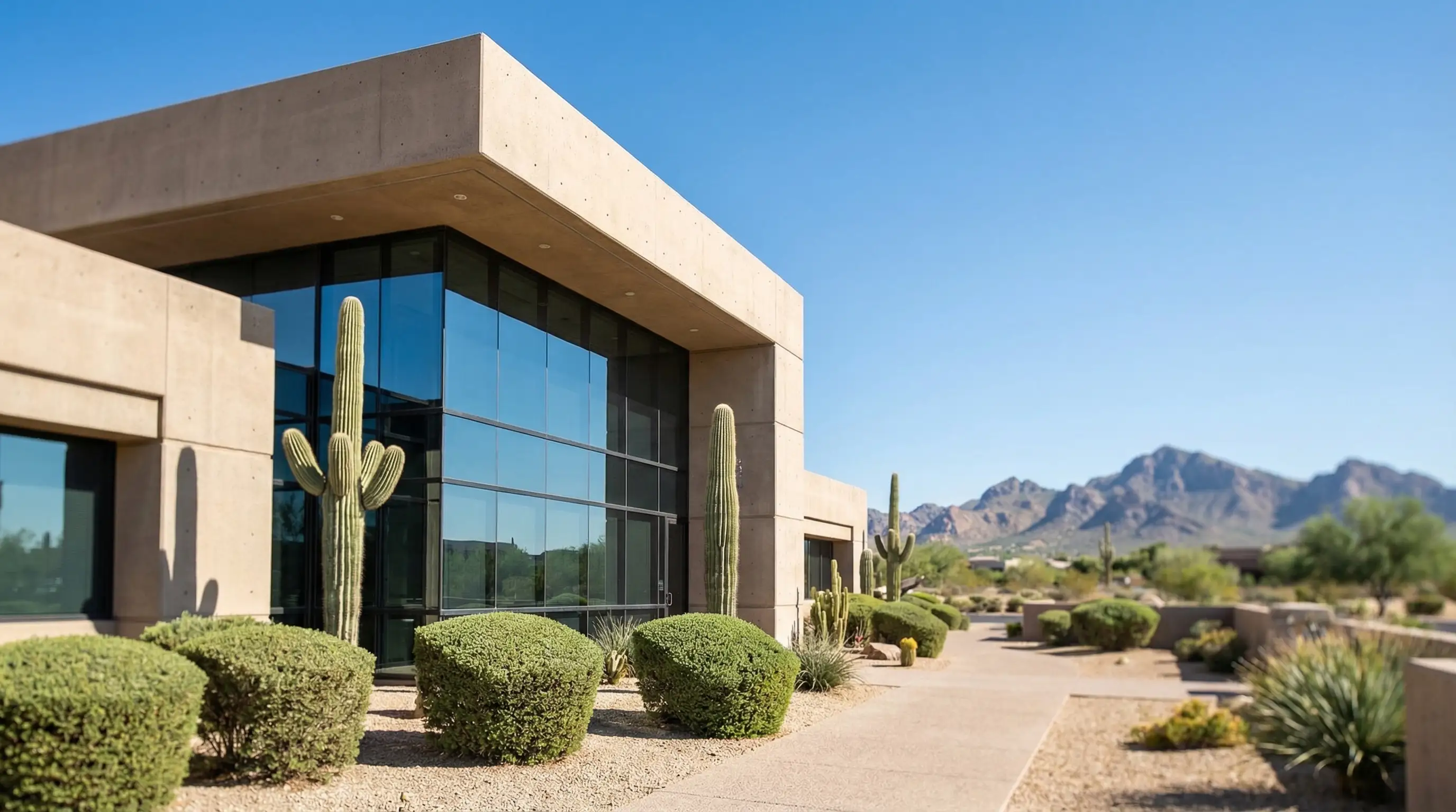 Interior conference room of an upscale Scottsdale law firm with attorney seated across from clients at a polished conference table, floor-to-ceiling windows with desert view in background