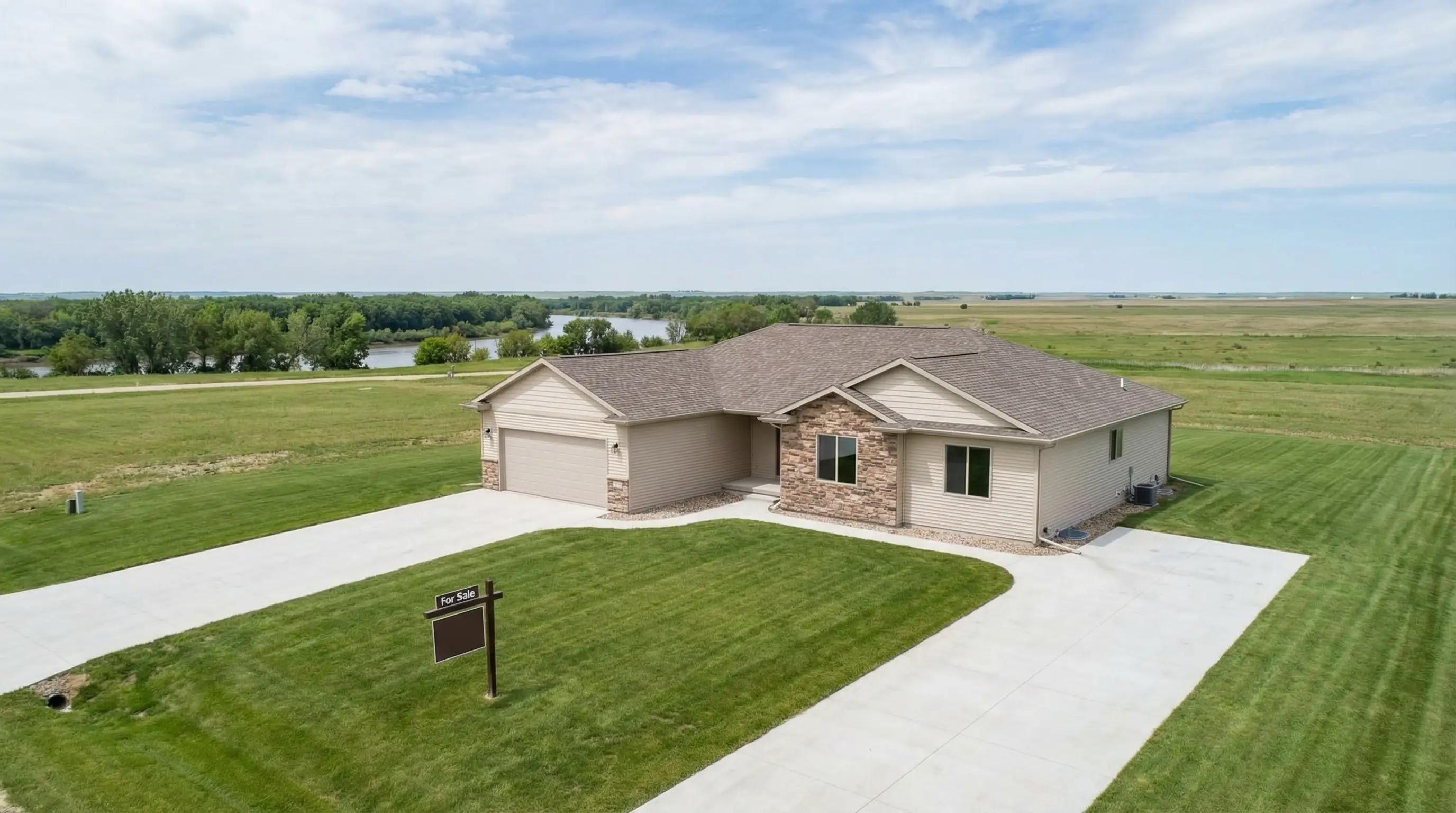 Real estate agent with tablet showing Zillow CMA report standing with a couple reviewing offer documents at a kitchen island in a modern Sioux Falls home with prairie sky visible through window.