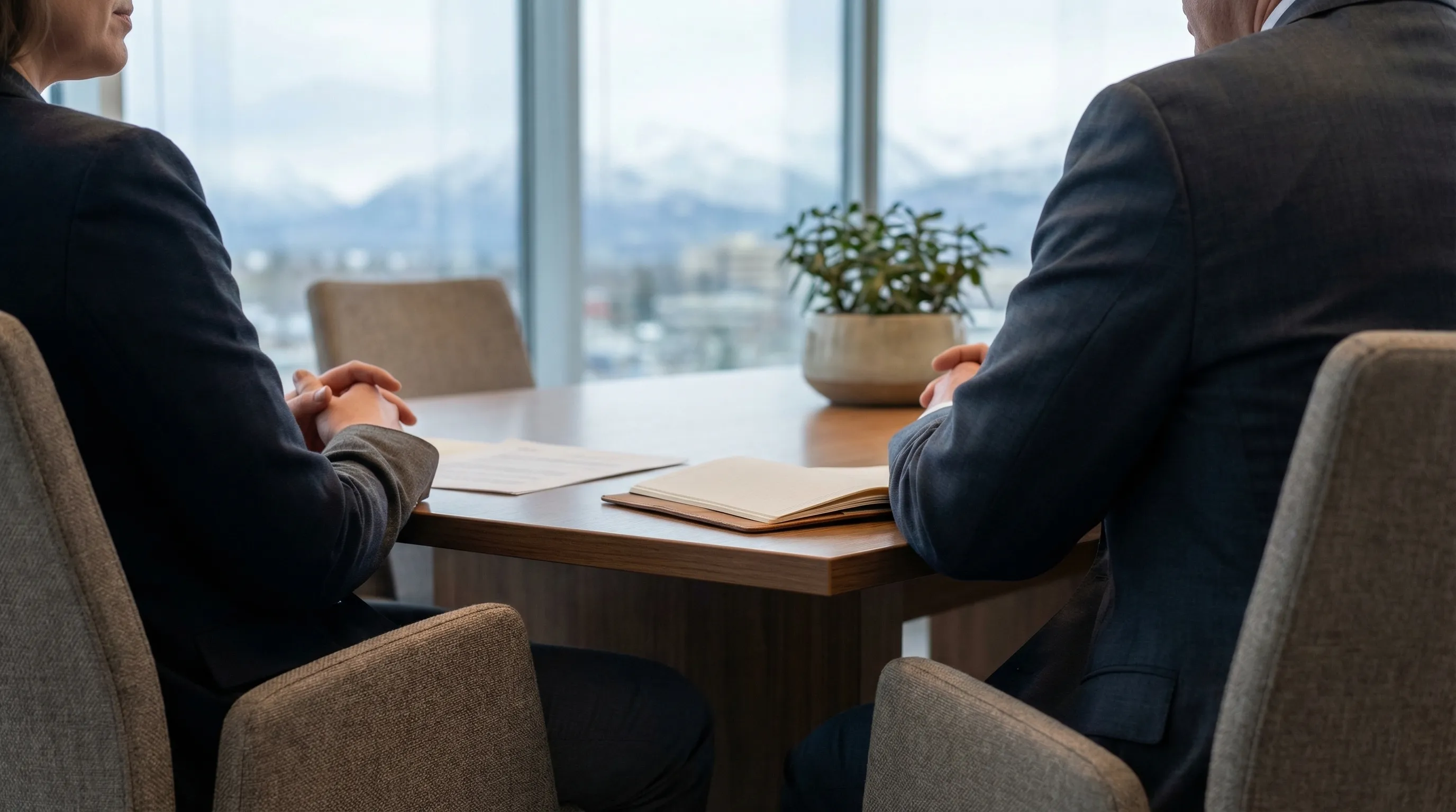 Professional attorney consulting with a client in a law office in downtown Anchorage, AK with mountain view