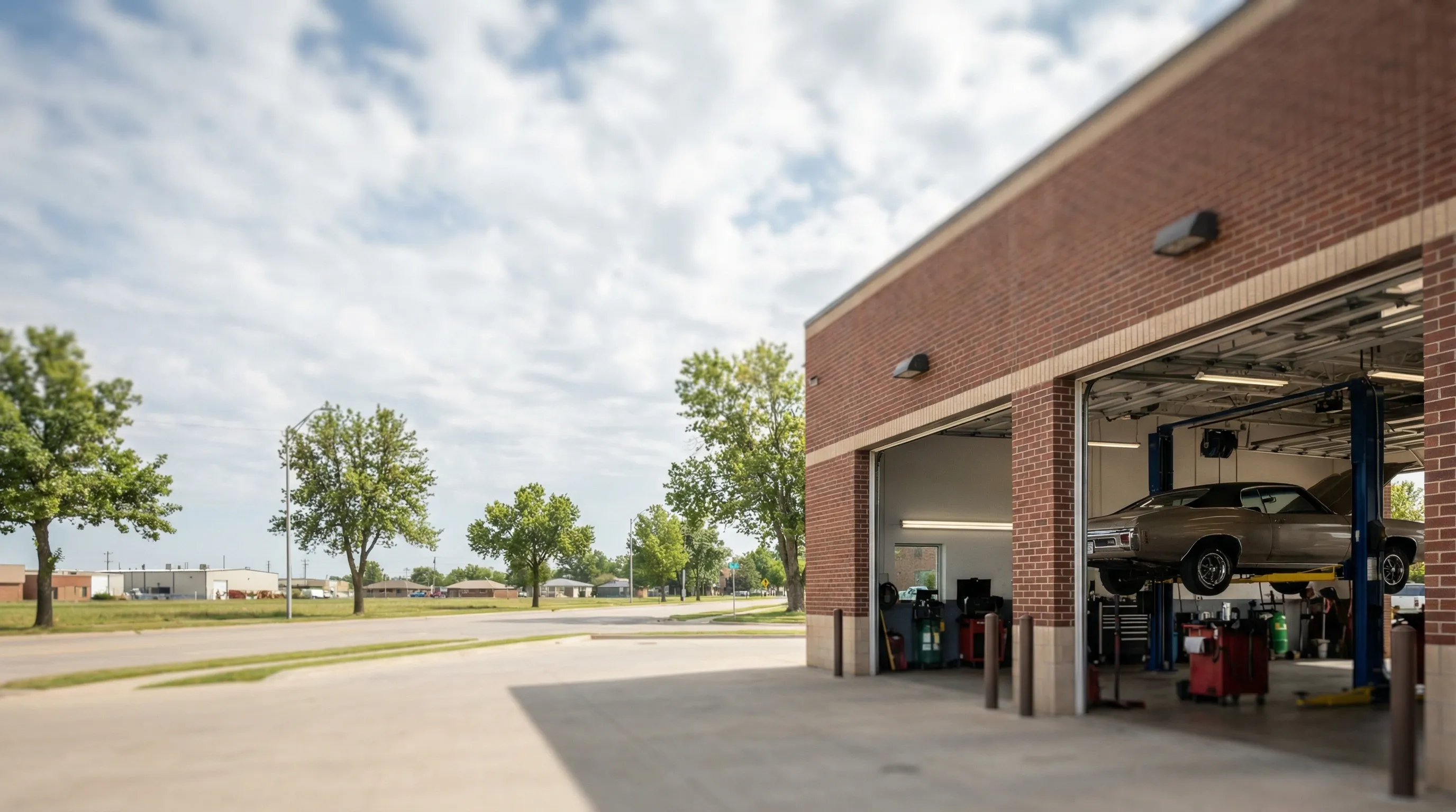 Auto technician in shop uniform explaining a repair diagnosis to a customer at a service counter in Wichita, KS