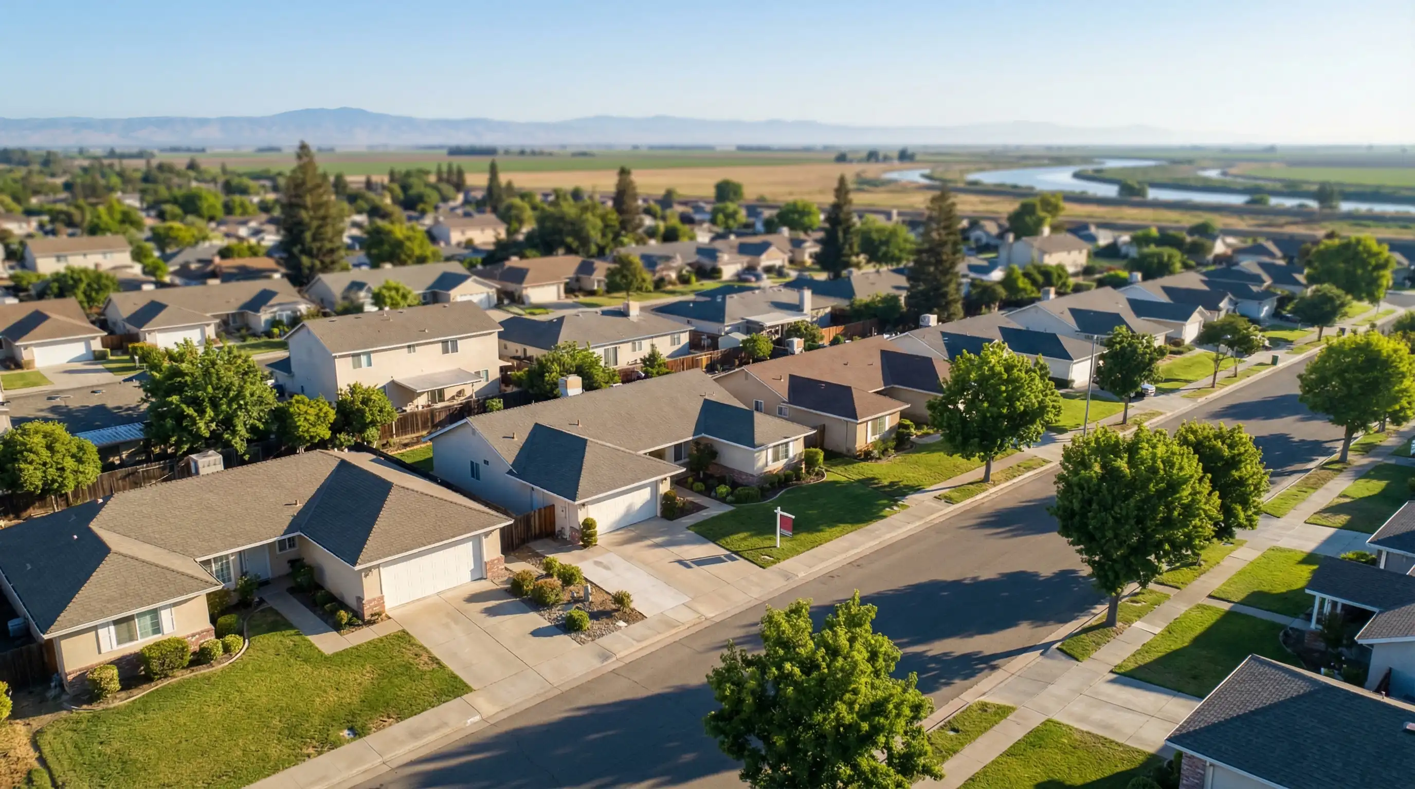 Real estate agent showing a young couple around a bright modern kitchen in a recently staged Stockton CA home with granite countertops and warm California light through large windows