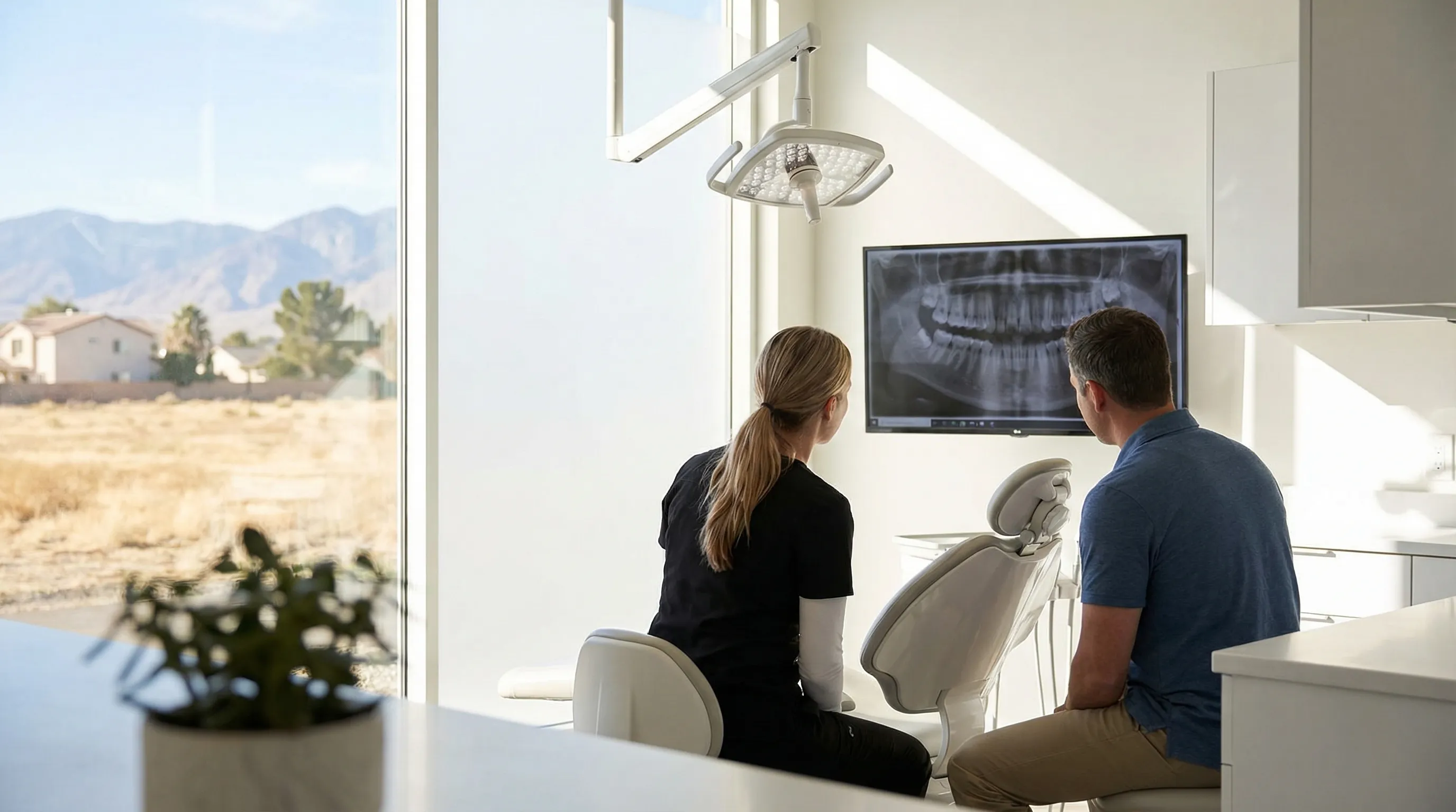 Dentist in scrubs and hygienist standing outside a modern clean dental office in a Stockton CA suburban strip center with bright signage, California blue sky, and palm trees in background