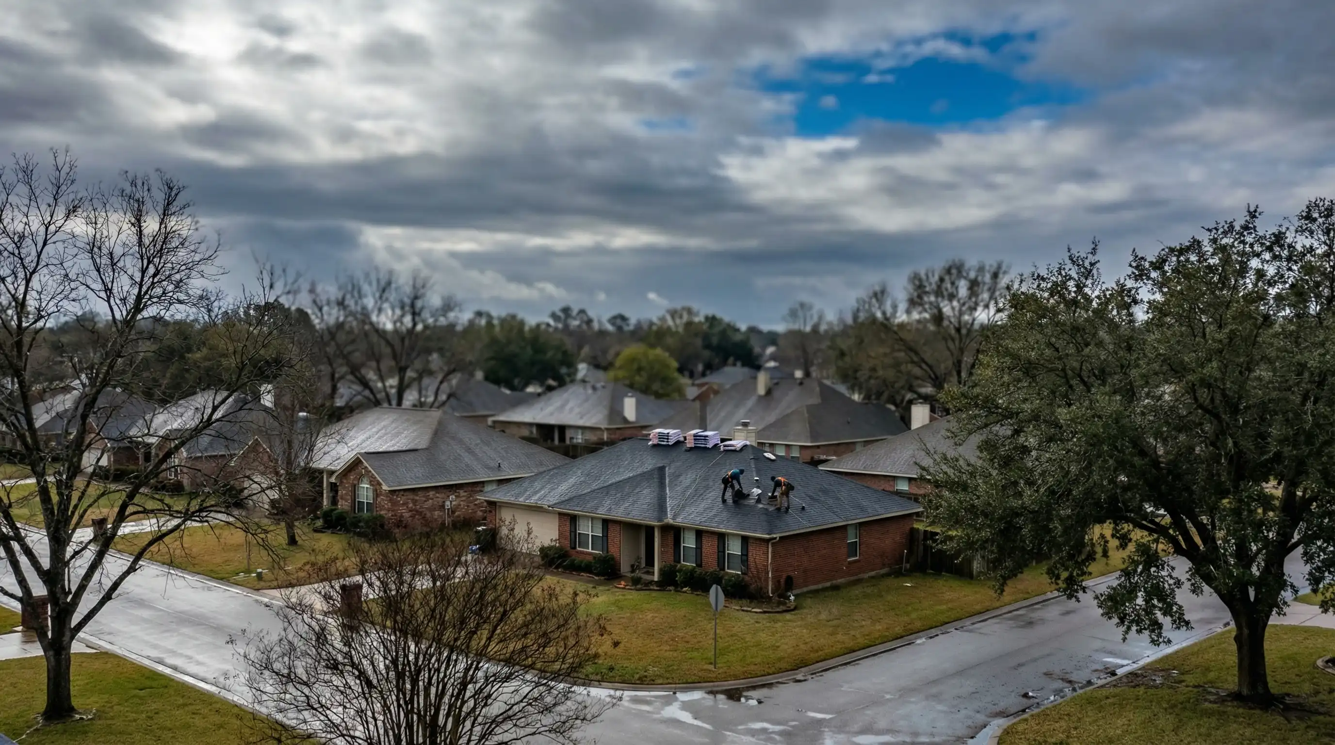 Professional roofing crew installing new shingles on a brick ranch home in a Waco TX neighborhood after a hail storm