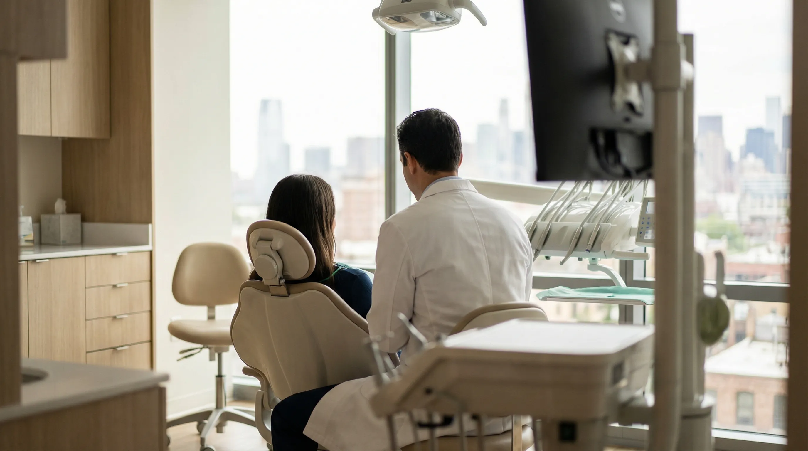 Professional dental consultation in a modern Jersey City dental office with a dentist speaking with a new patient in a clean, well-lit treatment room