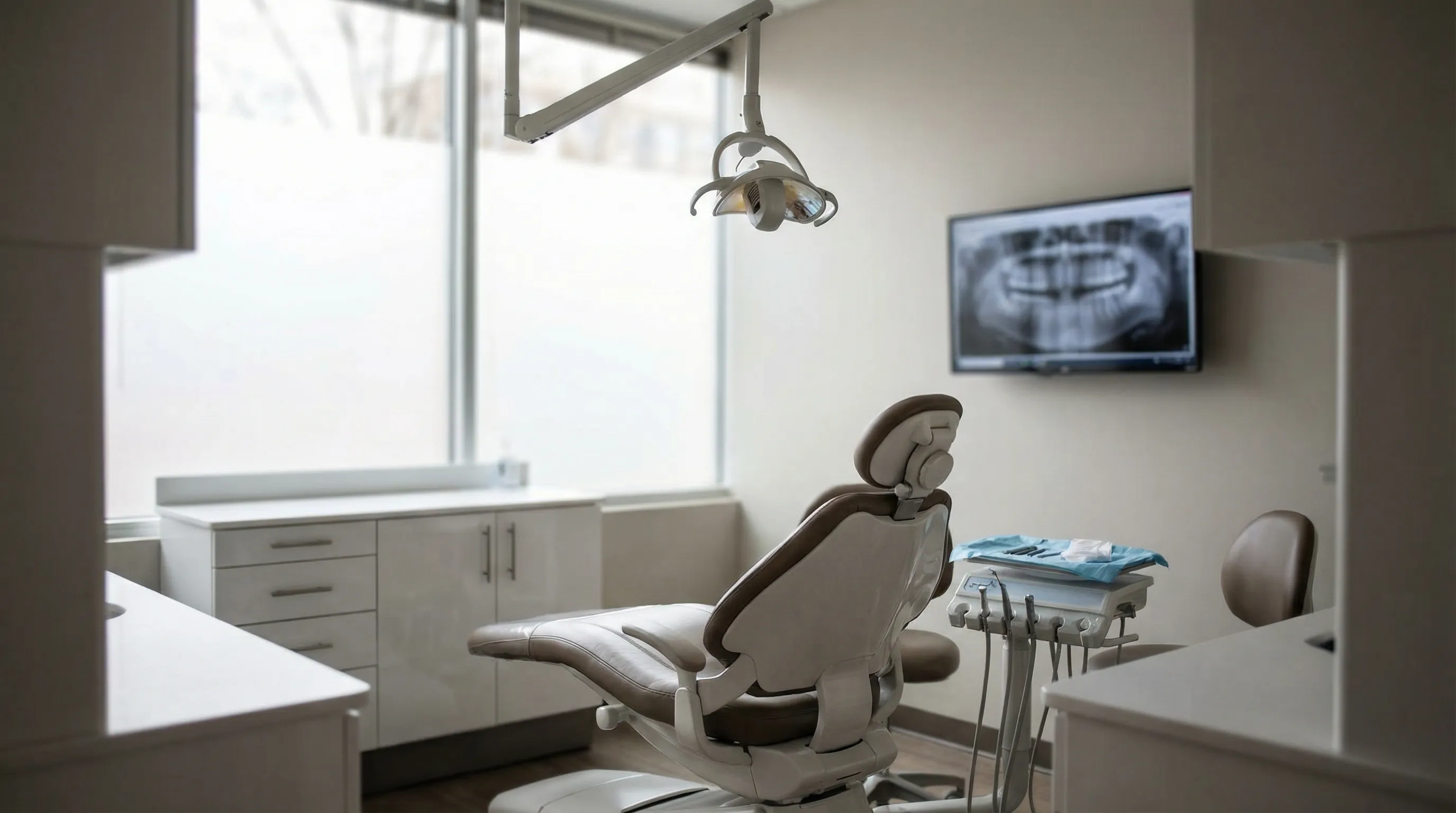 Modern dental treatment room in an Arlington, VA practice with digital X-ray equipment and natural light through frosted windows