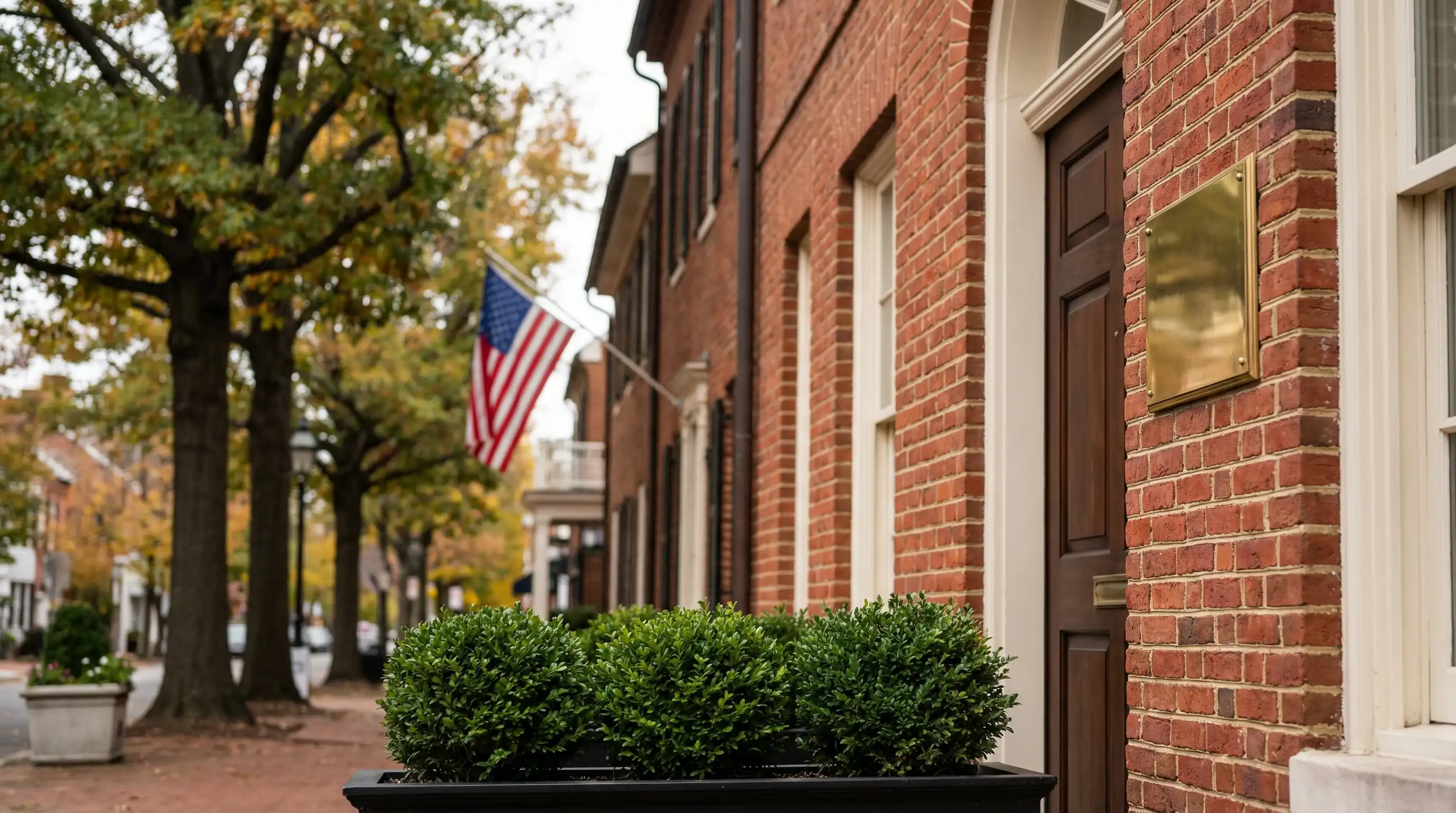 Professional financial advisor in a well-appointed consultation office in Alexandria, VA meeting with a client at a polished desk with portfolio documents visible