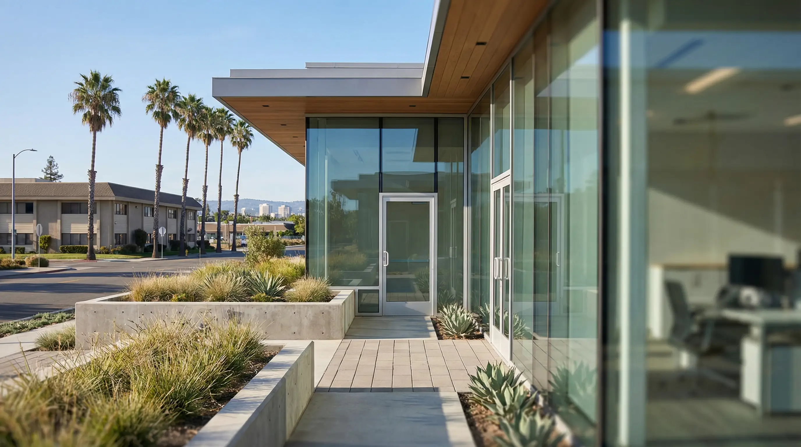 Financial advisor in modern Sunnyvale office reviewing RSU vesting calendar and tax projection dashboard with tech professional client at glass conference table, Sunnyvale street visible through large windows