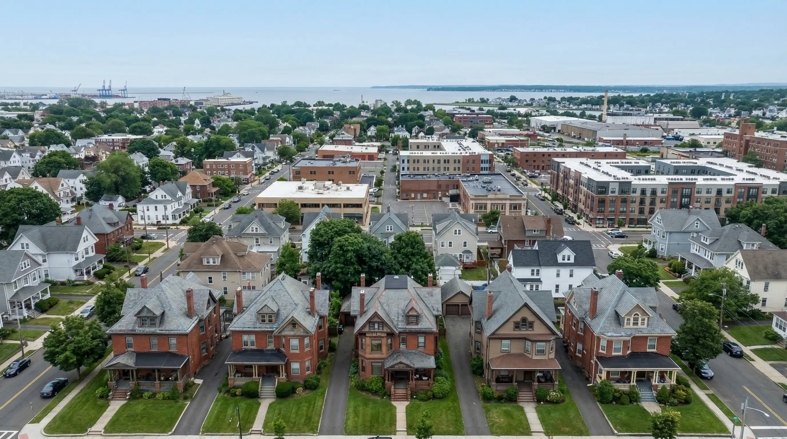 Aerial view of Bridgeport CT residential neighborhood with Victorian-era two-family homes and Long Island Sound visible in background