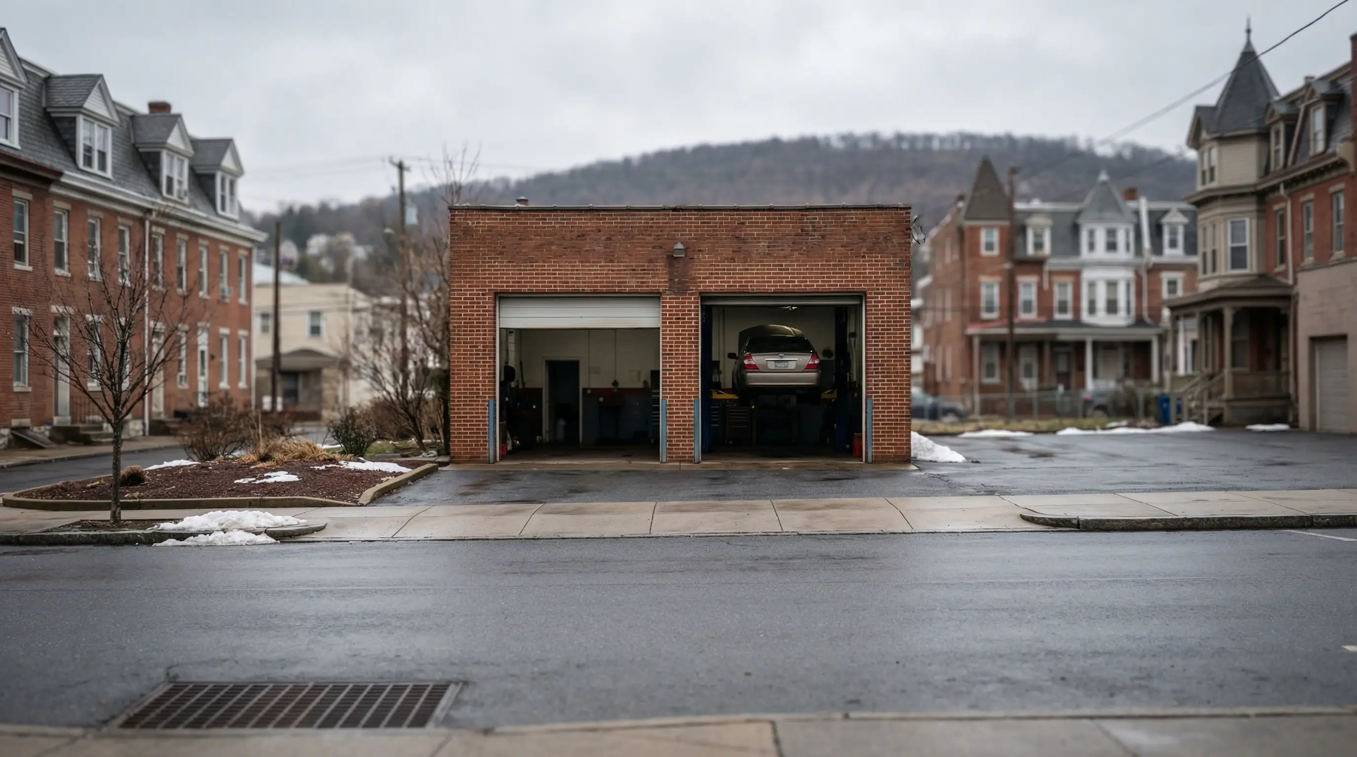 Independent auto repair mechanic working under vehicle on lift inside Allentown PA shop bay
