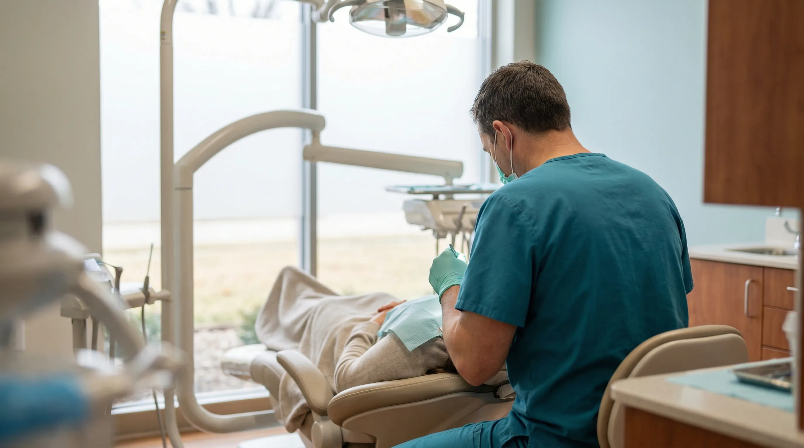 Dentist providing dental care to patient in modern Evansville, IN dental office