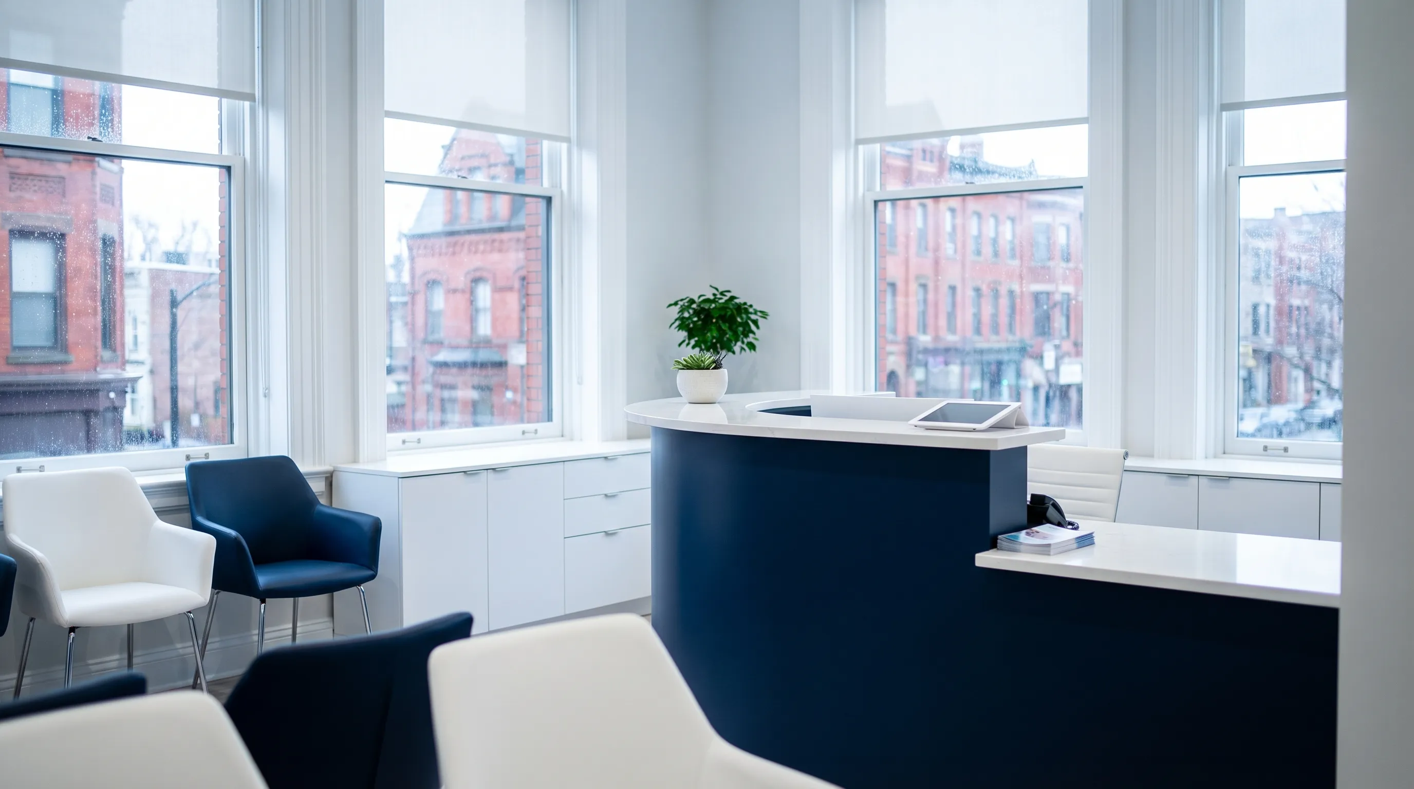 Modern dental office reception in Waterbury CT with warm lighting, dental assistant welcoming a Latino family, clean professional environment signaling accessible family dental care