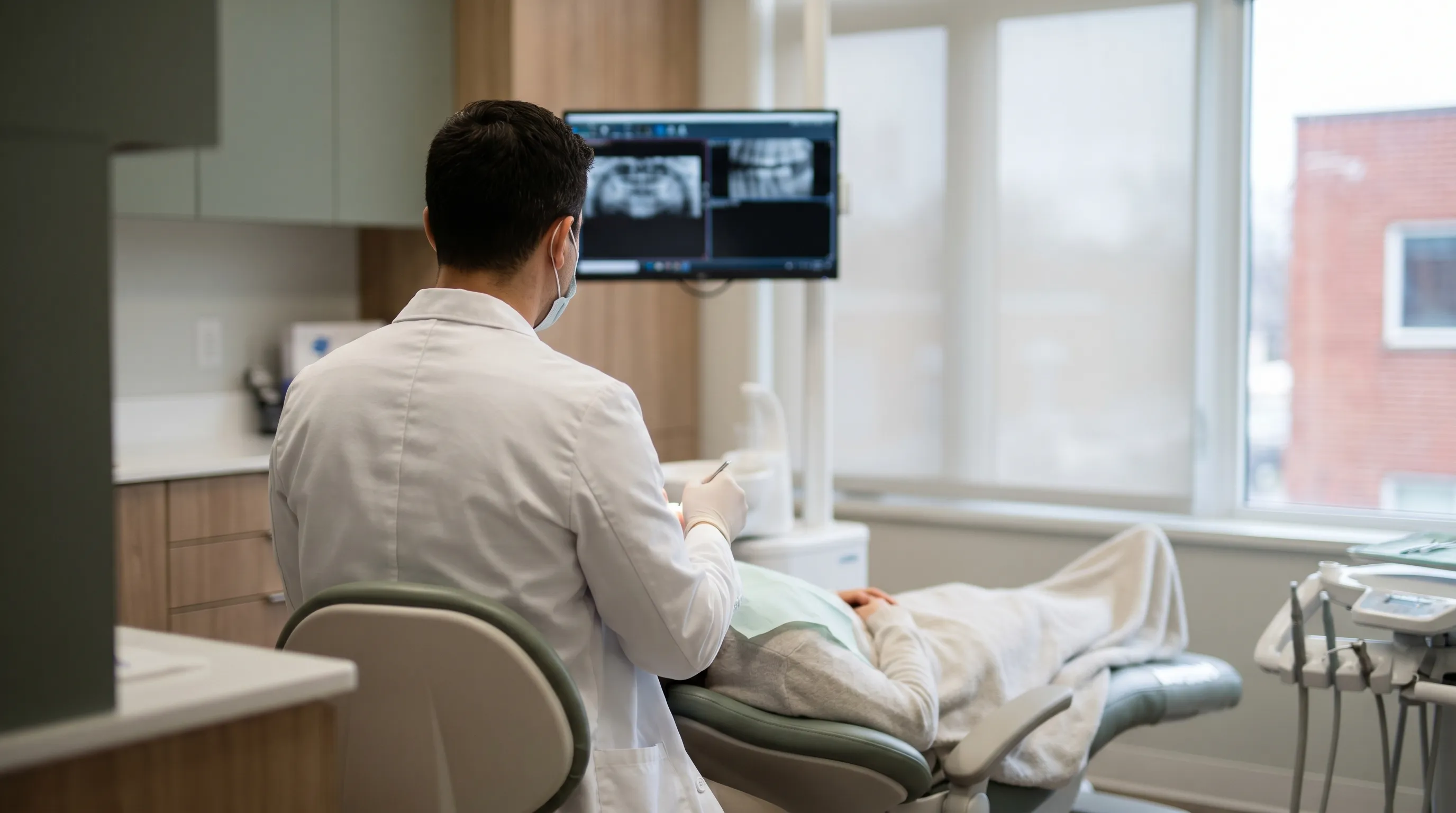 Professional dental office with dentist and patient in a modern treatment room in Lansing, MI