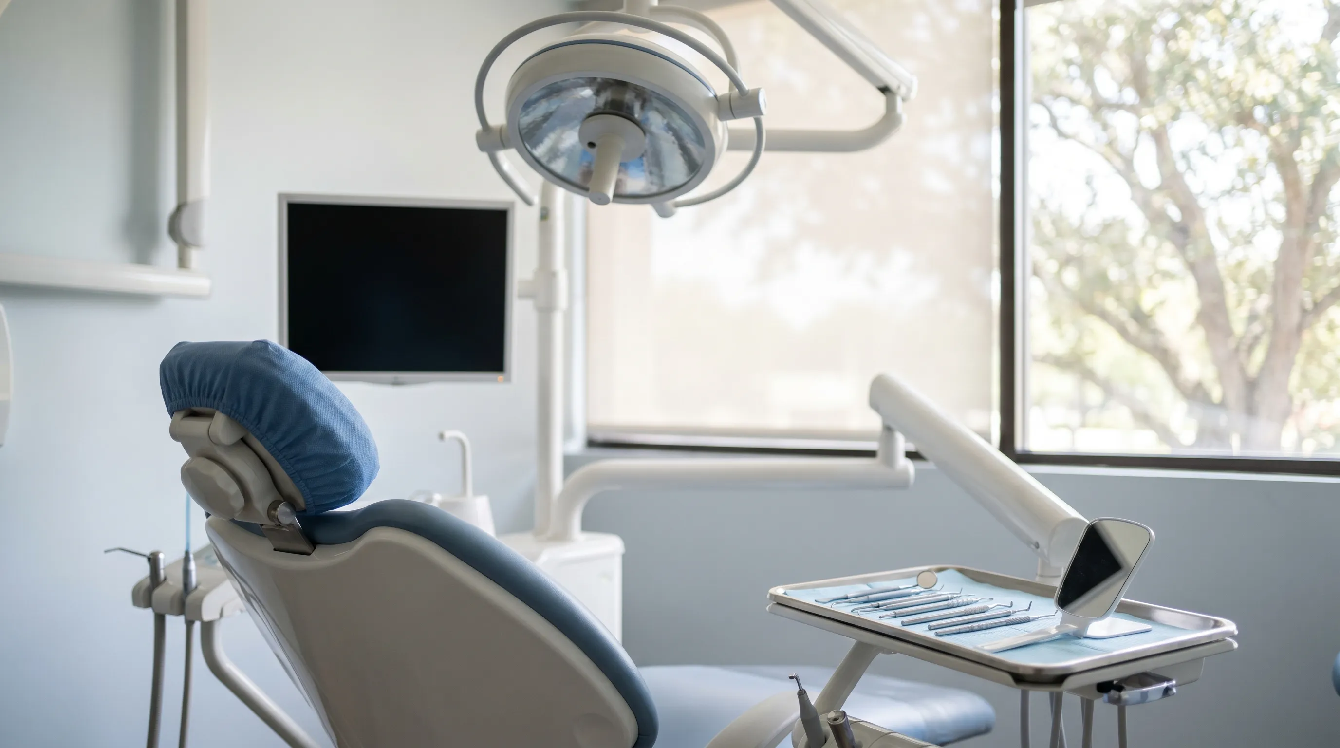 Professional dentist and hygienist working alongside a patient in a modern Peoria, IL dental treatment room