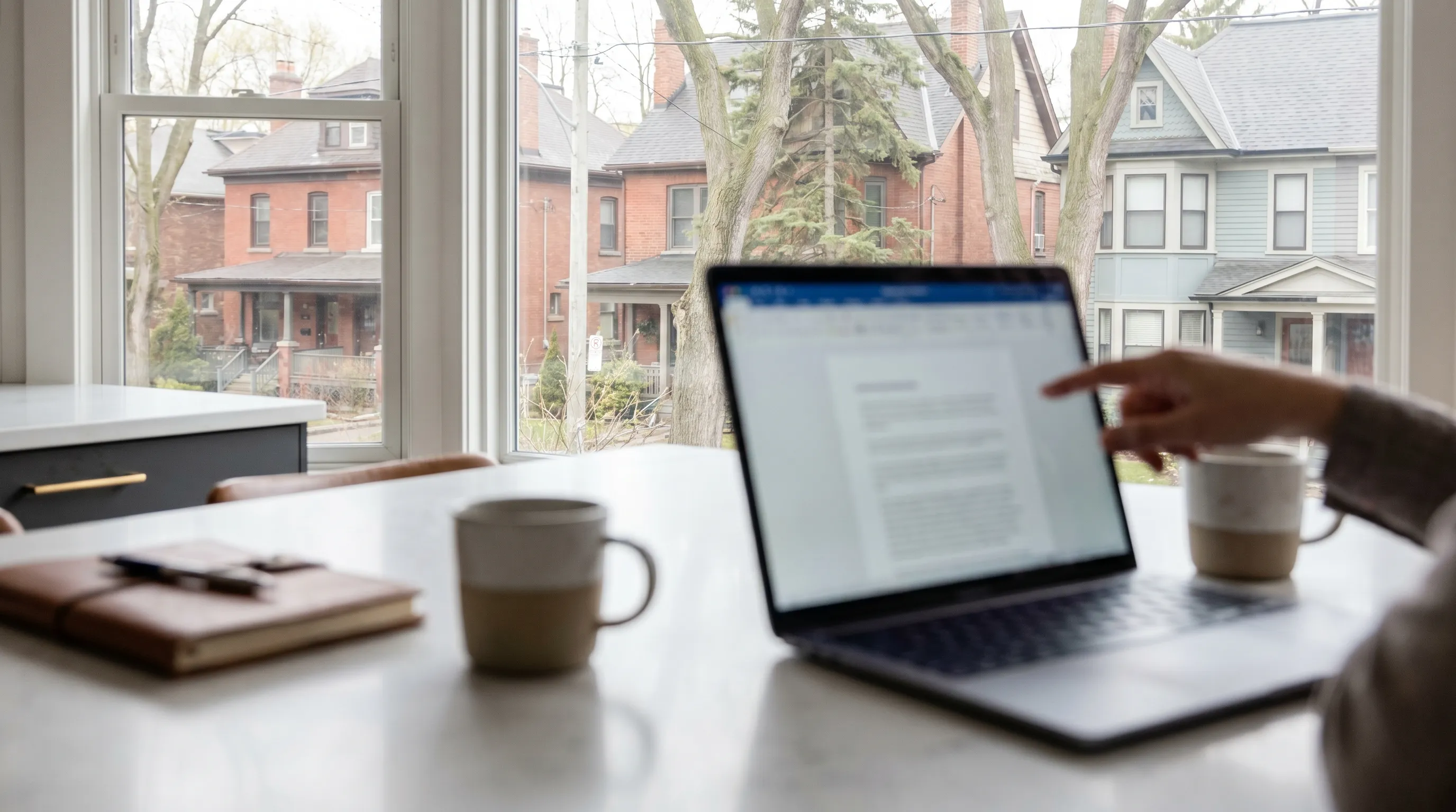 Professional real estate agent reviewing listing data with homeowners at a kitchen table in a Kenosha, WI home