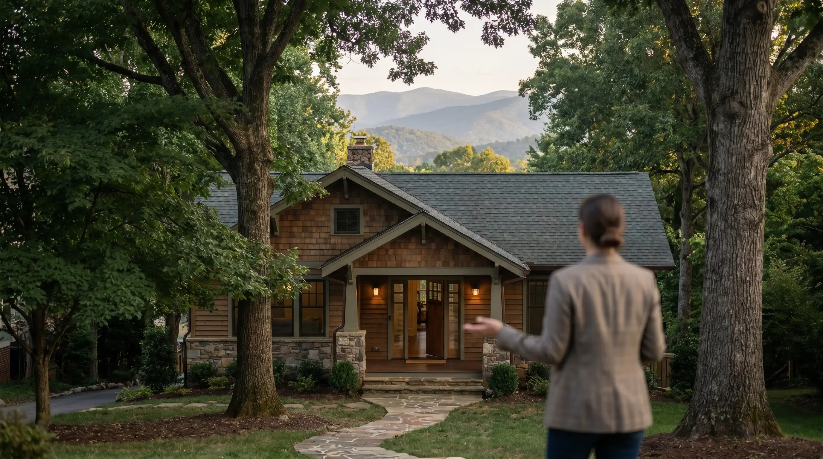 Real estate agent reviewing property listings with a couple at a kitchen table inside a craftsman-style home in Asheville, NC, mountain view through window