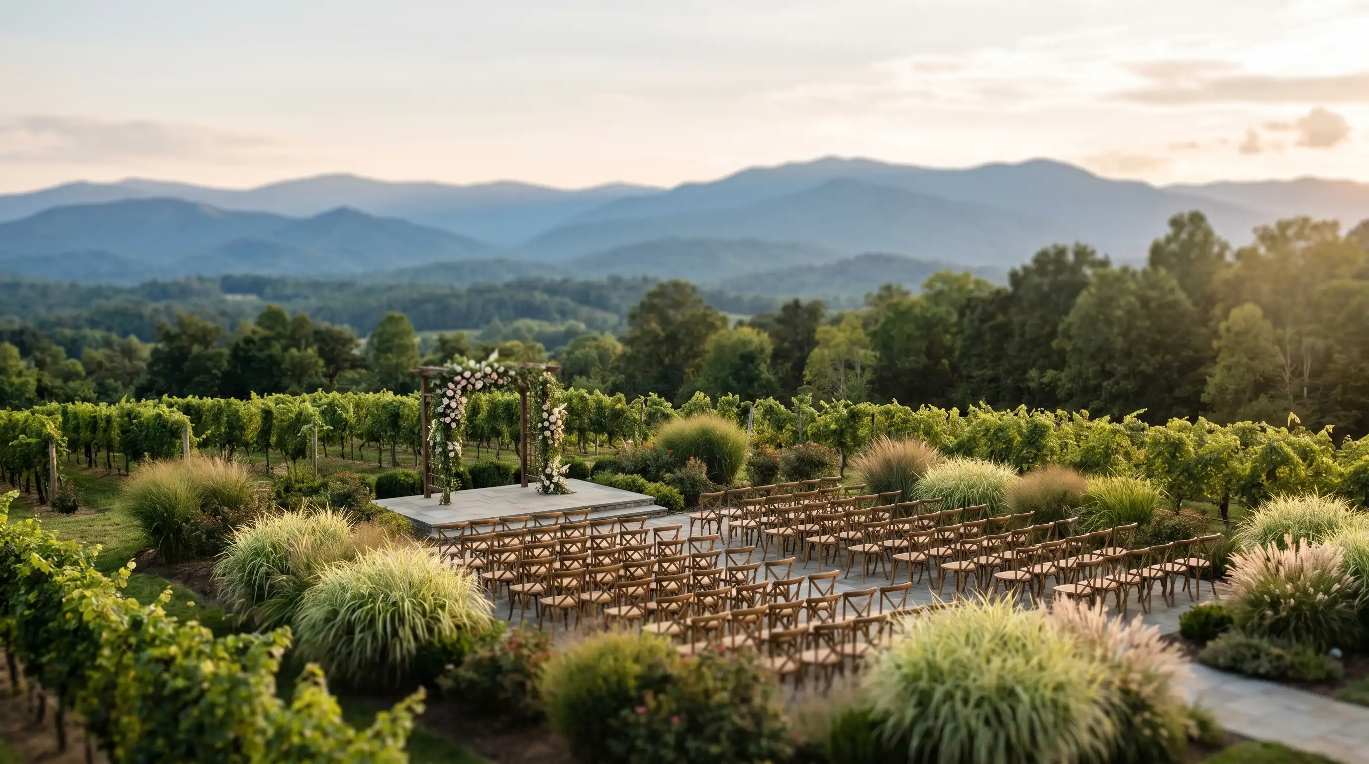 Outdoor wedding ceremony at a mountain meadow venue near Asheville, NC, with Blue Ridge Mountain panorama in background and guests seated in wooden chairs at golden hour