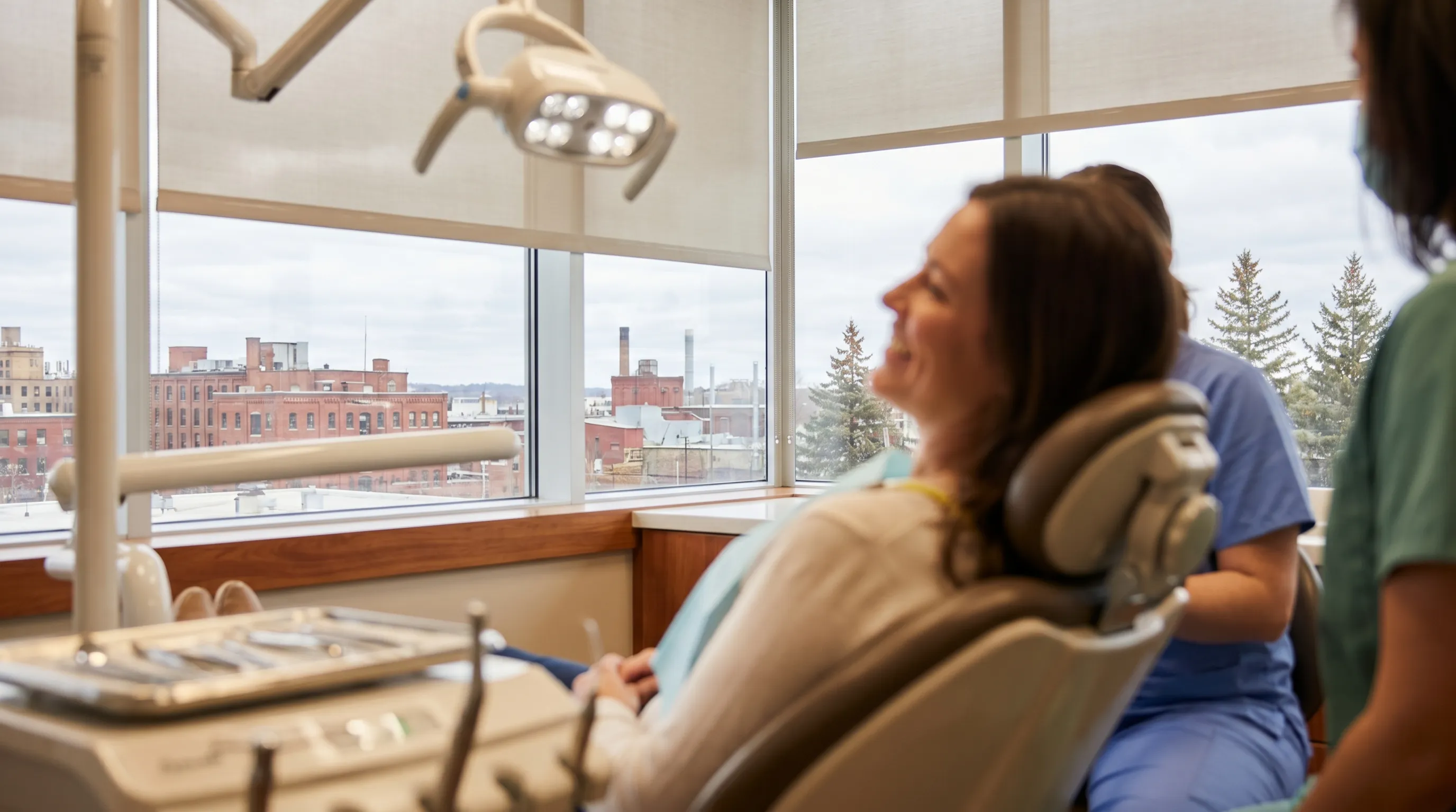 Dental professional performing a patient consultation in a modern Duluth, MN dental office with city views