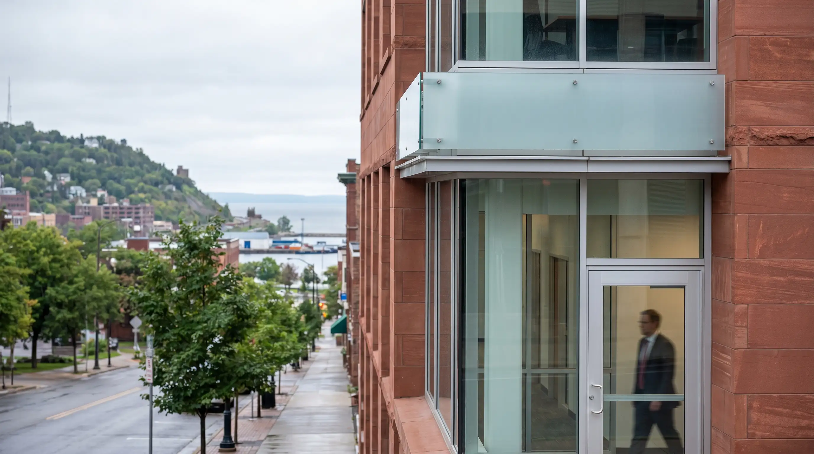 Personal injury attorney consulting with a client in a professional Duluth, MN law office with Lake Superior visible through the window