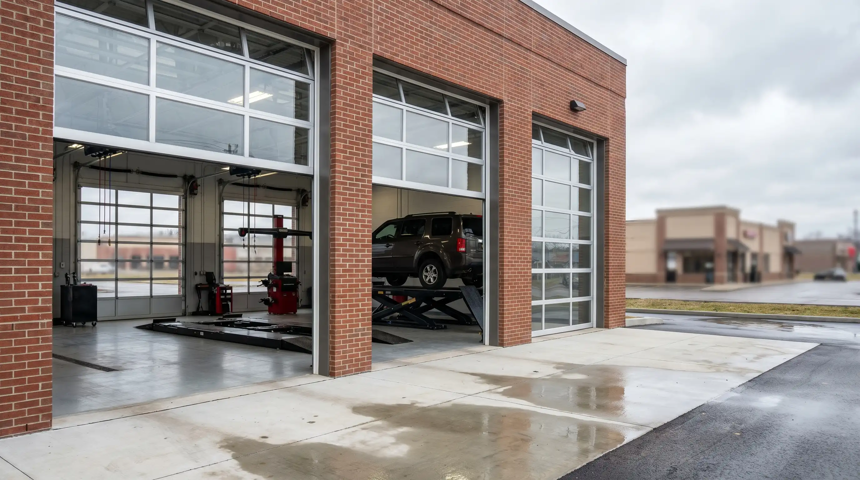 Mechanic performing oil change on lifted vehicle in Bloomington, IN auto repair shop service bay