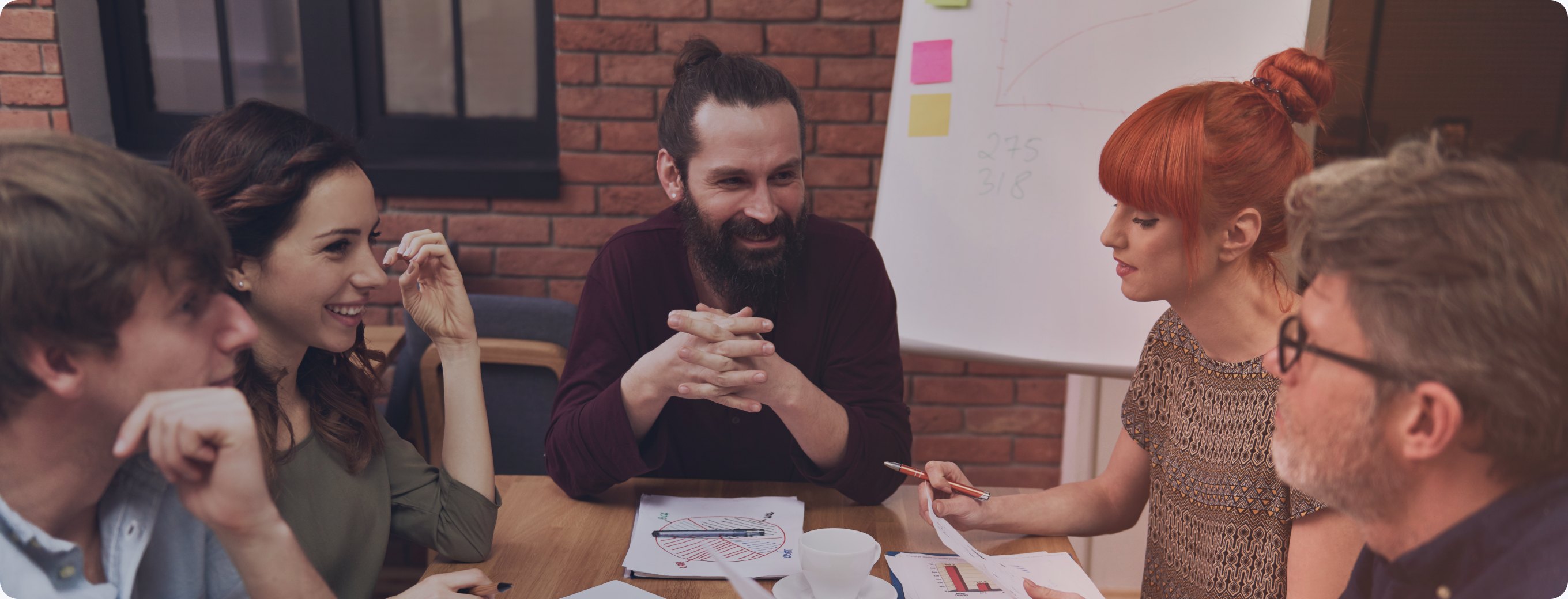 A marketing team talking through messaging notes around a table