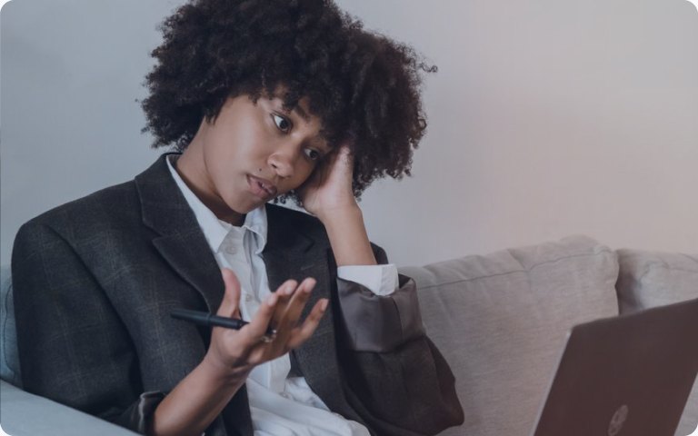 A frustrated professional gesturing at her laptop